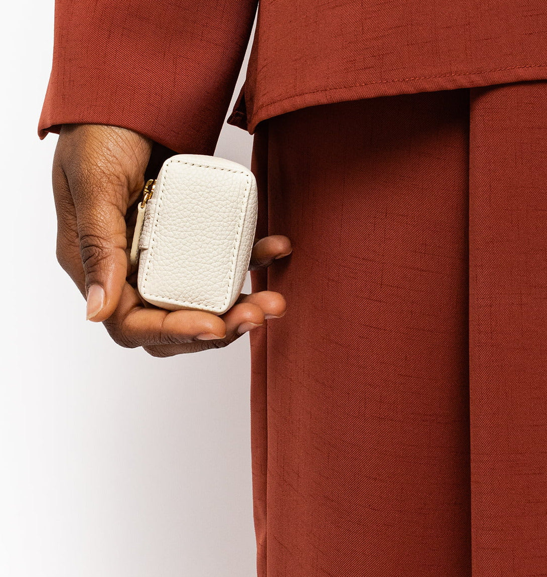 STOW Spring Moon Mini Essentials Case being held by model wearing deep red suit