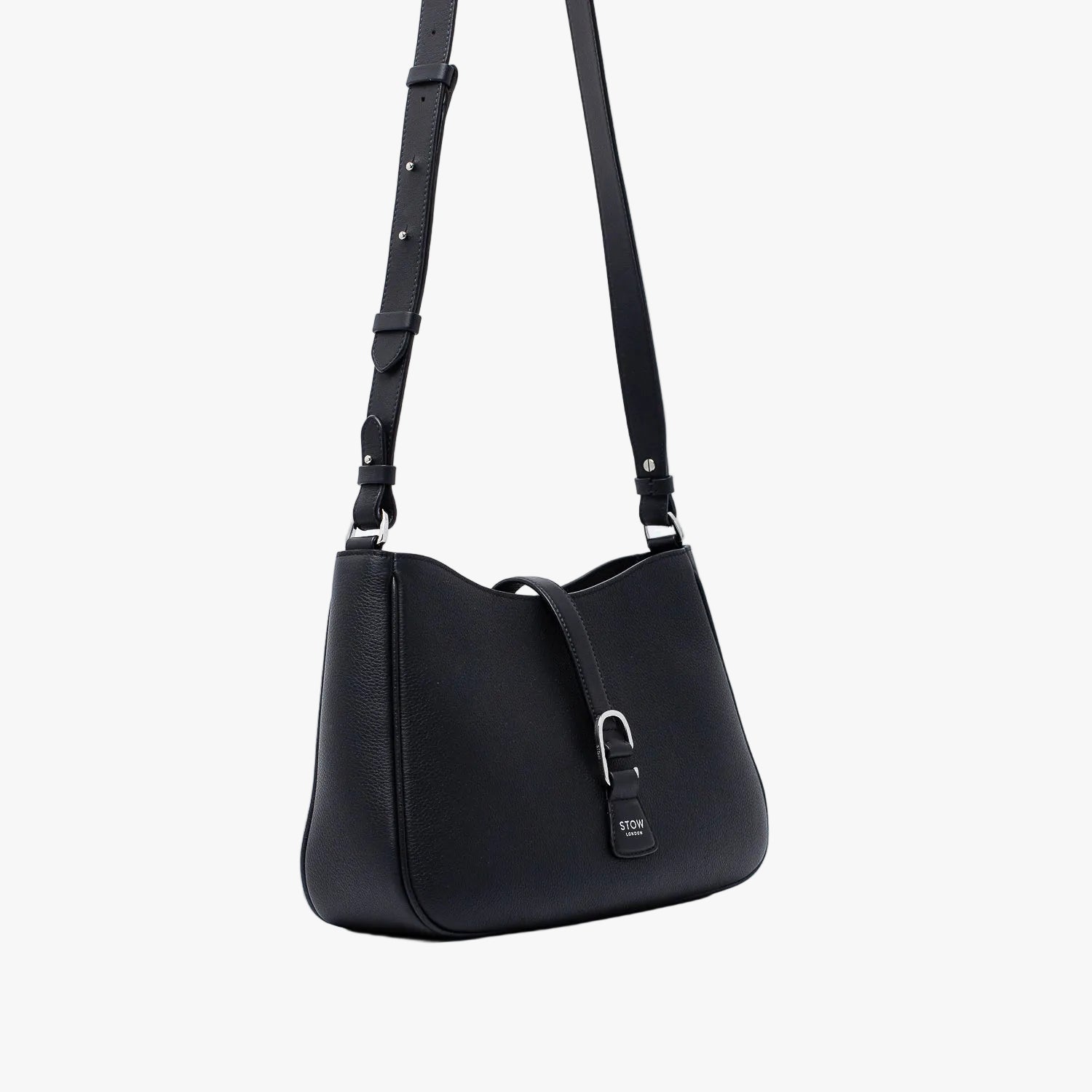 Off-axis view of STOW London's Beth bag and detachable crossbody strap in Black leather featuring silver stainless steel hardware on a white background