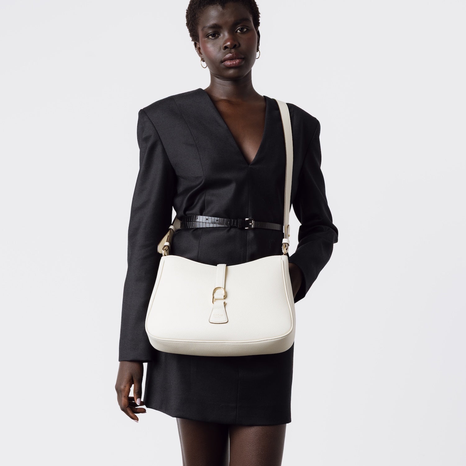 Model wearing STOW London's Beth bag and detachable crossbody strap in Spring Moon leather featuring gold stainless steel hardware on a white background