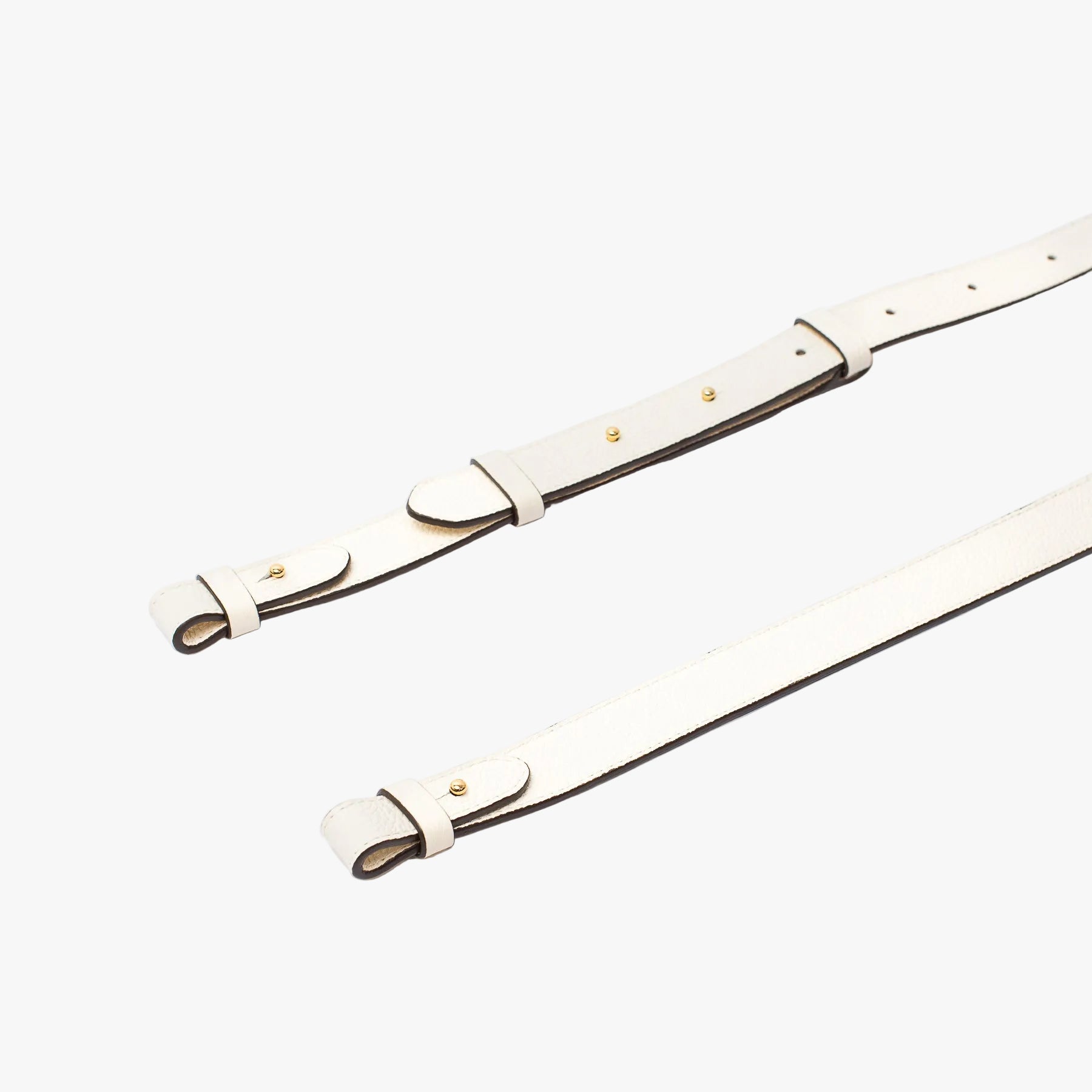 Close up shot of STOW London's detachable crossbody strap for the Beth bag in Spring Moon leather featuring Gold stainless steel hardware on a white background