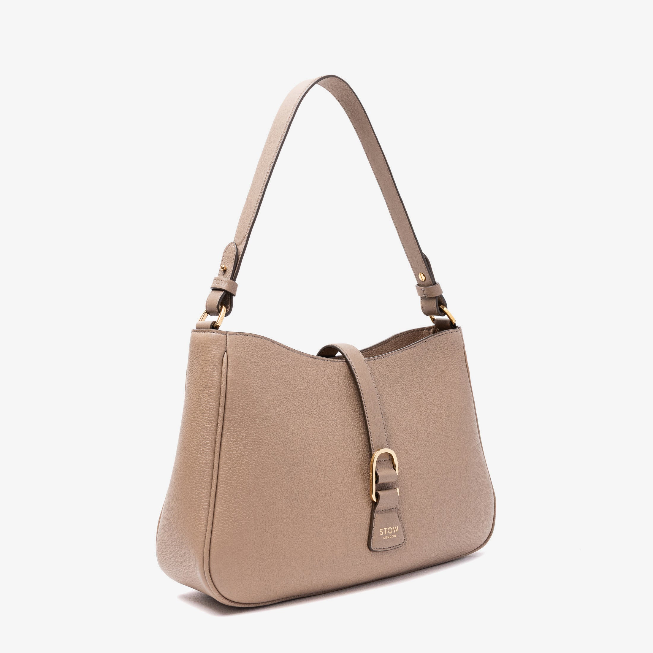 Off-axis view of STOW London's Beth bag in Warm Taupe pebbled and smooth leather featuring gold-coated stainless steel hardware and clip on a white background