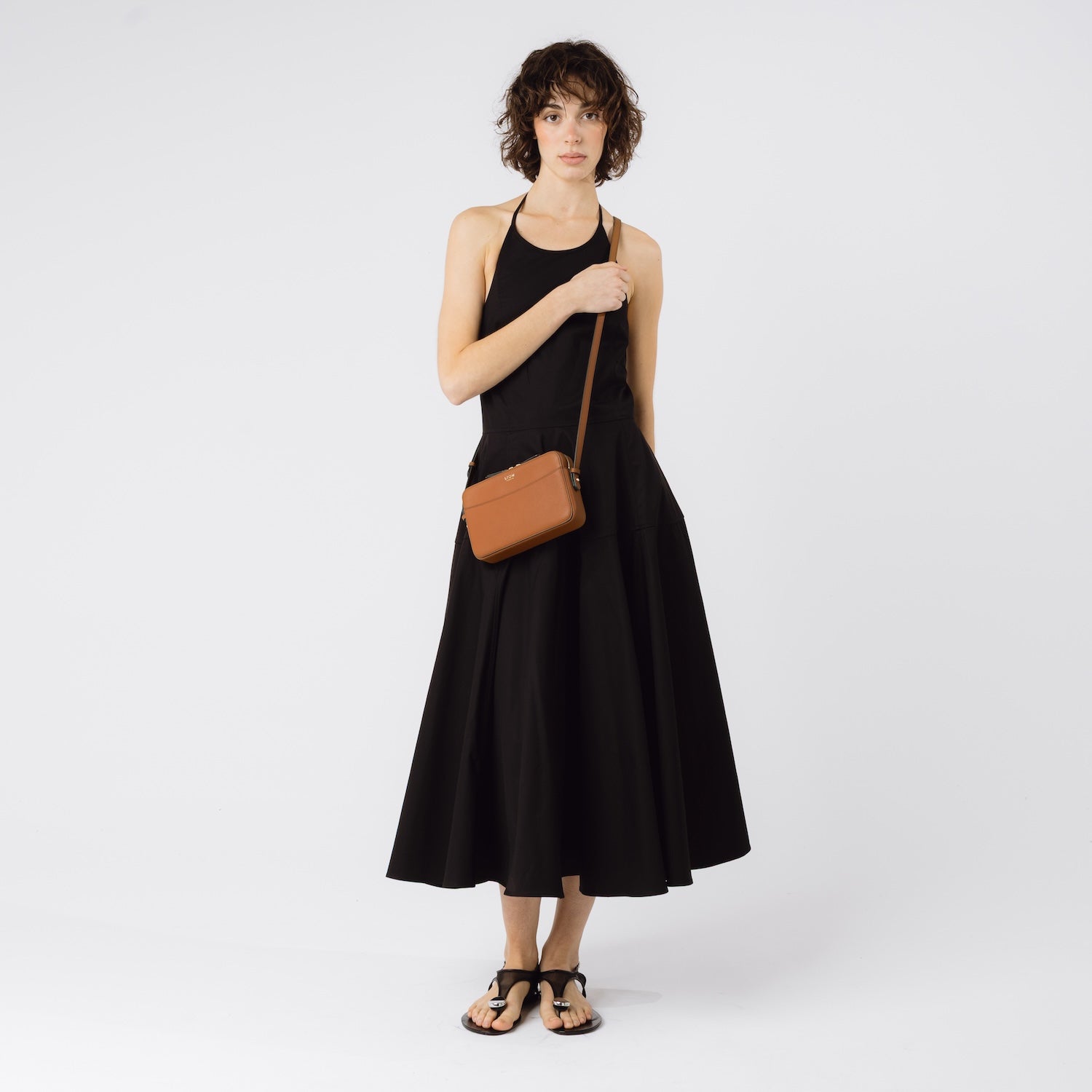 Model wearing STOW London's Camera bag in Earth Tan smooth leather crossbody featuring gold-coated stainless steel hardware