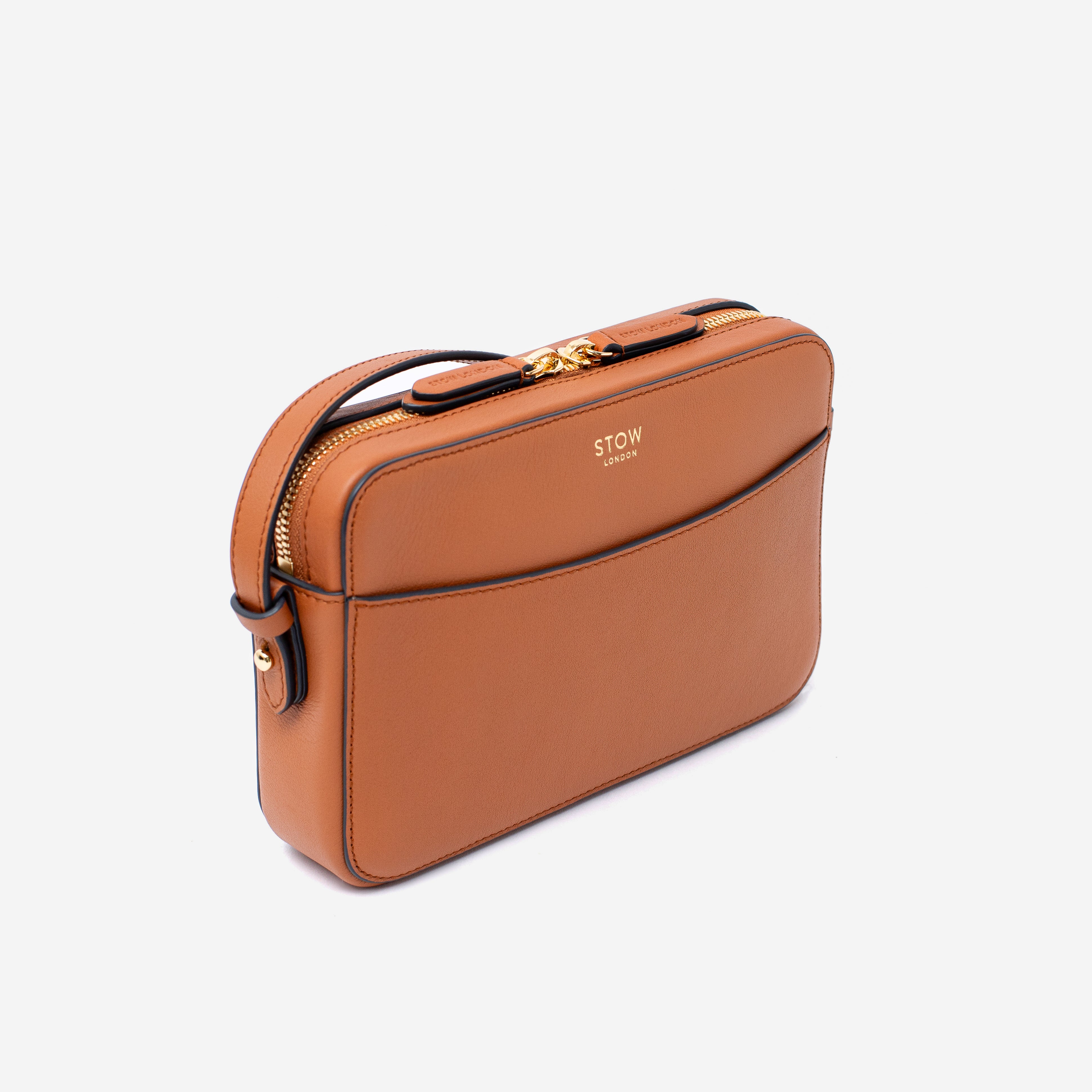 Off-axis view of STOW London's Camera bag in Earth Tan Smooth leather featuring gold-coated stainless steel hardware on a white background