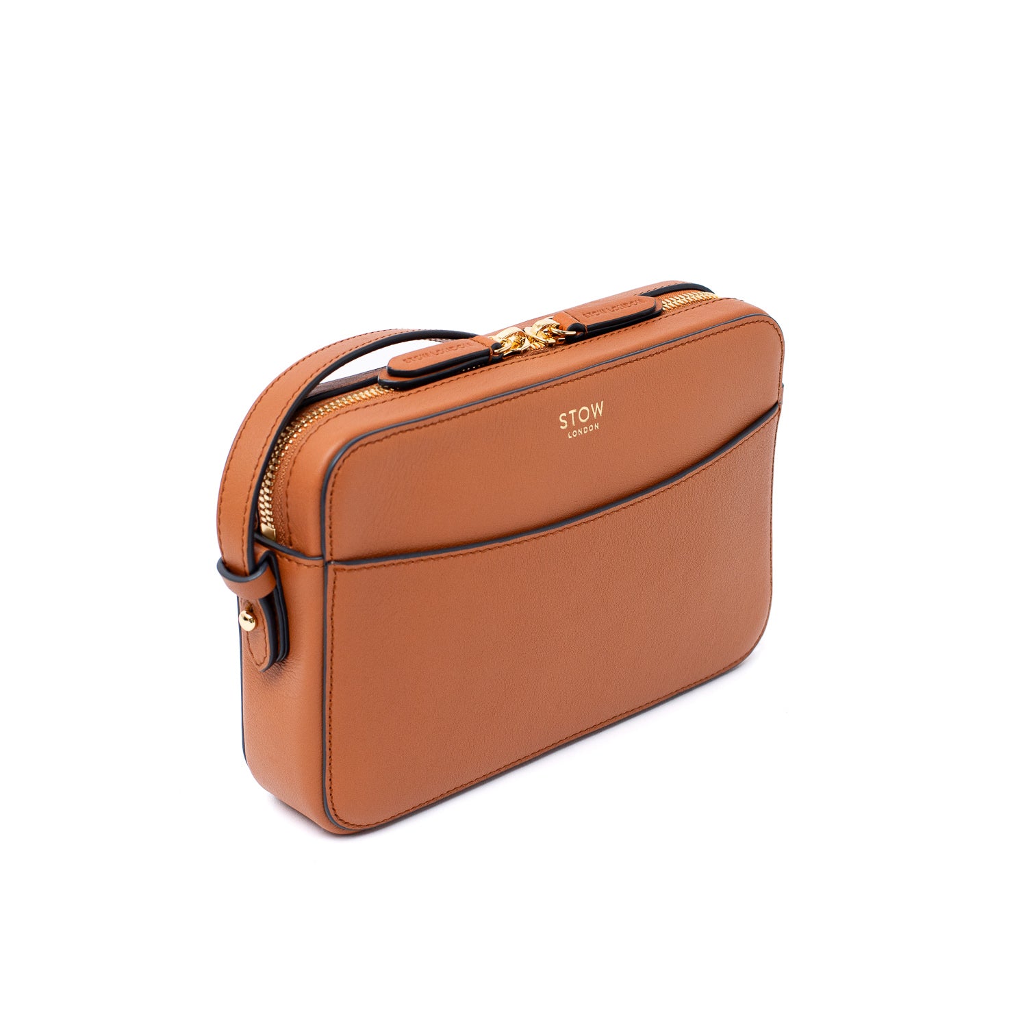 Off-axis shot of STOW London's Camera bag in Earth Tan smooth leather with detachable crossbody strap featuring gold-coated stainless steel hardware on a white background