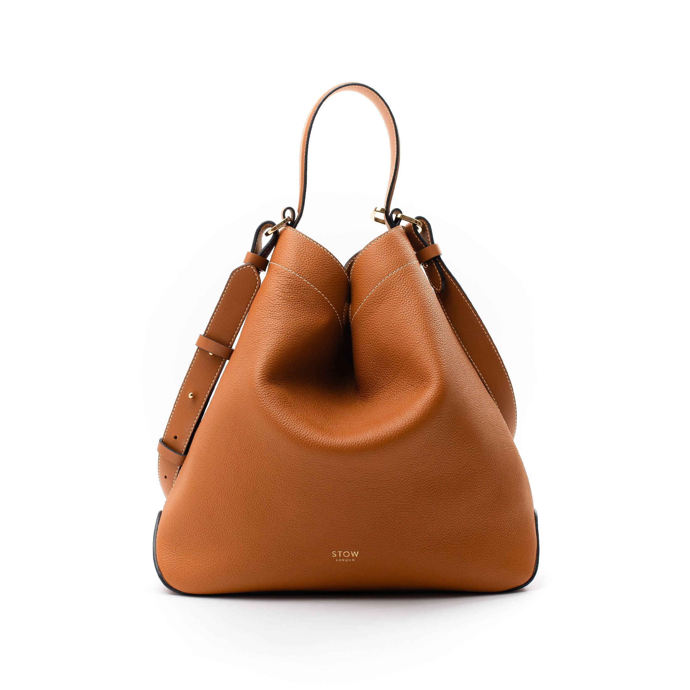 STOW London's Curve bag in Earth Tan pebbled and smooth leather featuring gold-coated stainless steel hardware on a white background