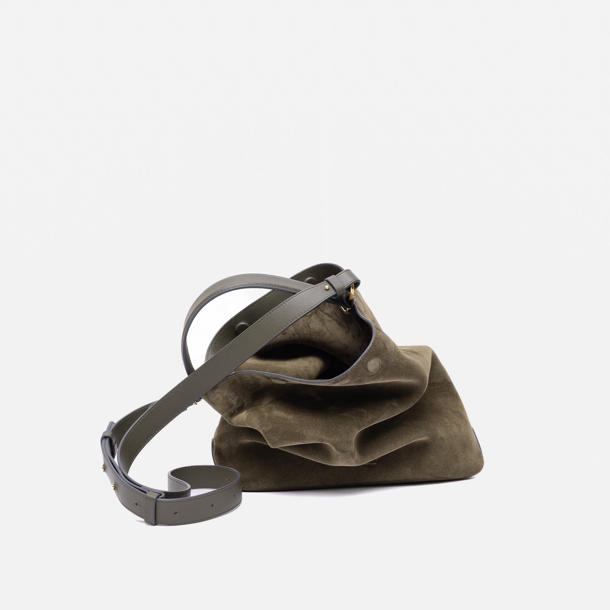 Stow London's Curve bag in Dark Green suede leather and detachable crossbody strap featuring gold-coated stainless steel hardware on a light grey background