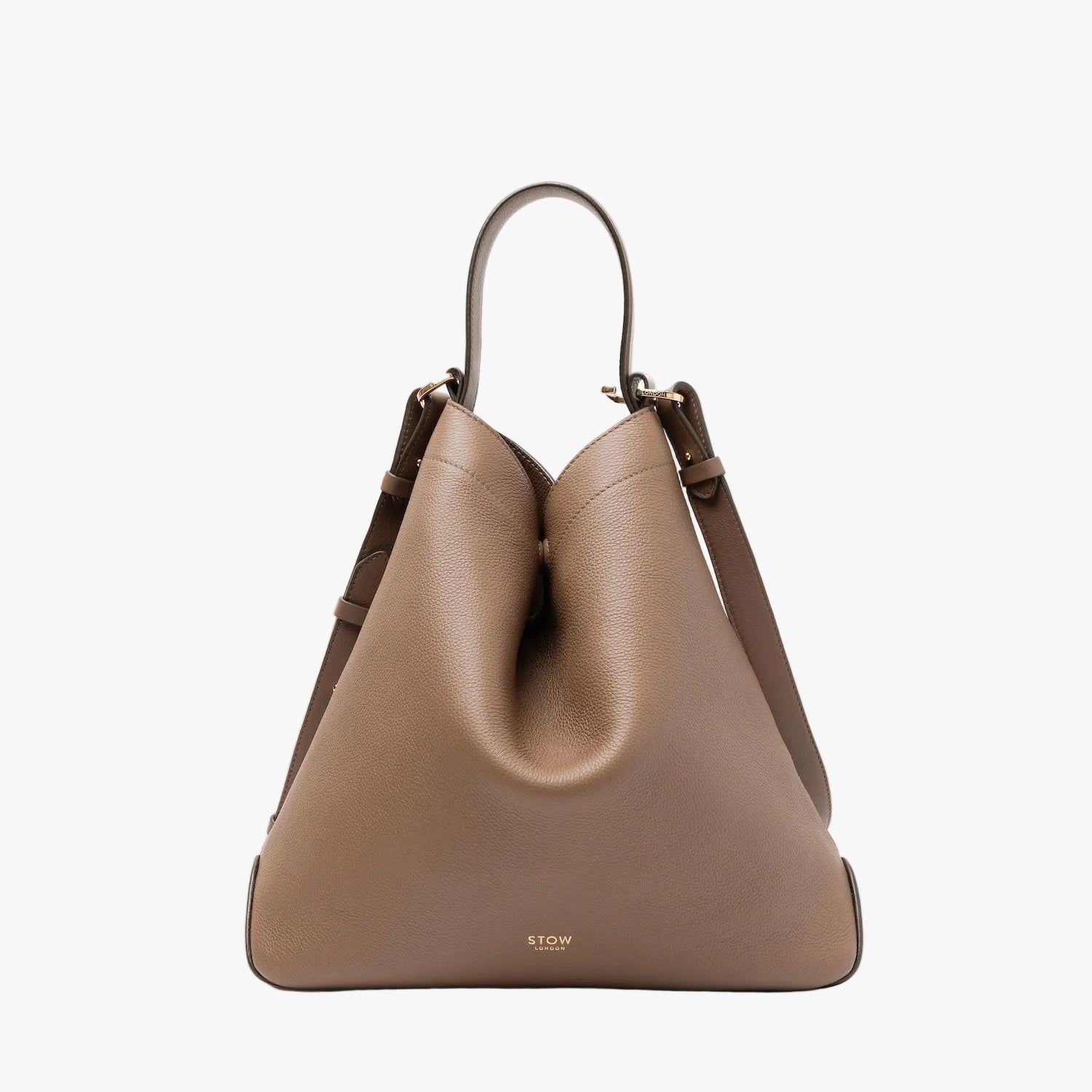 STOW London's Curve bag in Mocha pebbled leather shaped in its triangular form featuring gold-coated stainless steel hardware on a light grey background