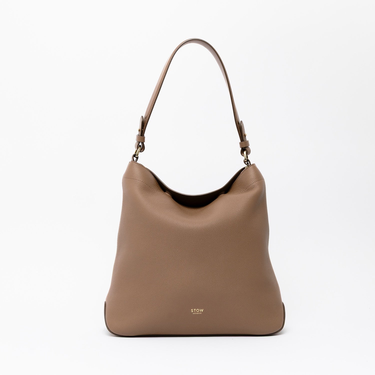 STOW London's Curve in Mocha leather on a light grey background featuring the detachable shoulder strap with gold hardware and details