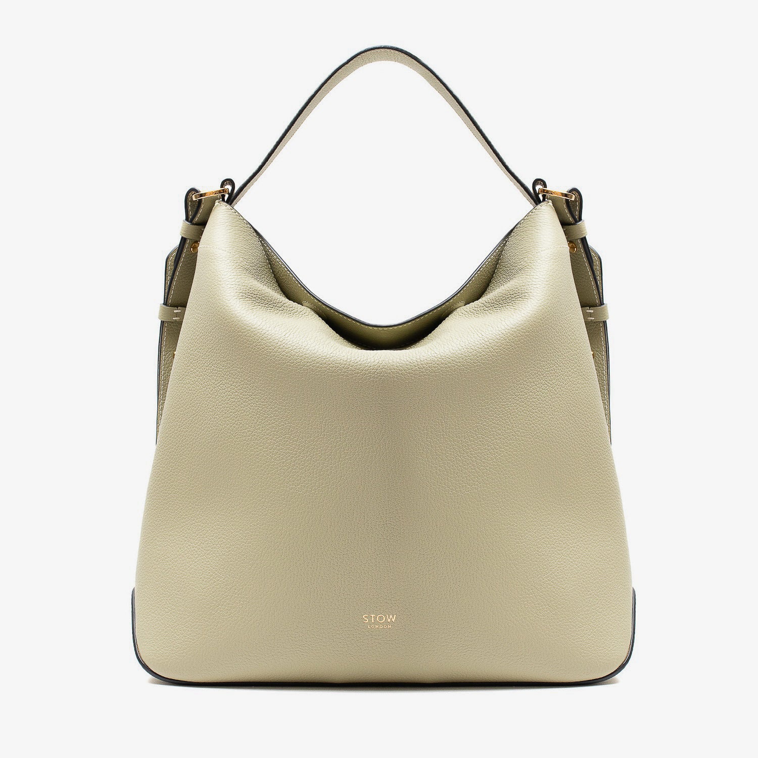 Stow London's Curve bag in Pale Green pebbled leather featuring gold-coated stainless steel hardware on a light grey background