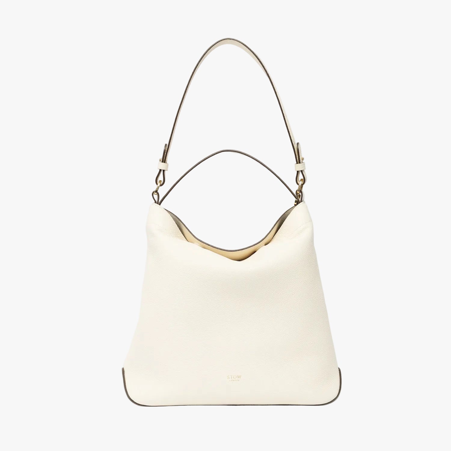 STOW London's Curve in Spring Moon leather on a light grey background featuring the detachable shoulder strap and top handle with gold hardware and details