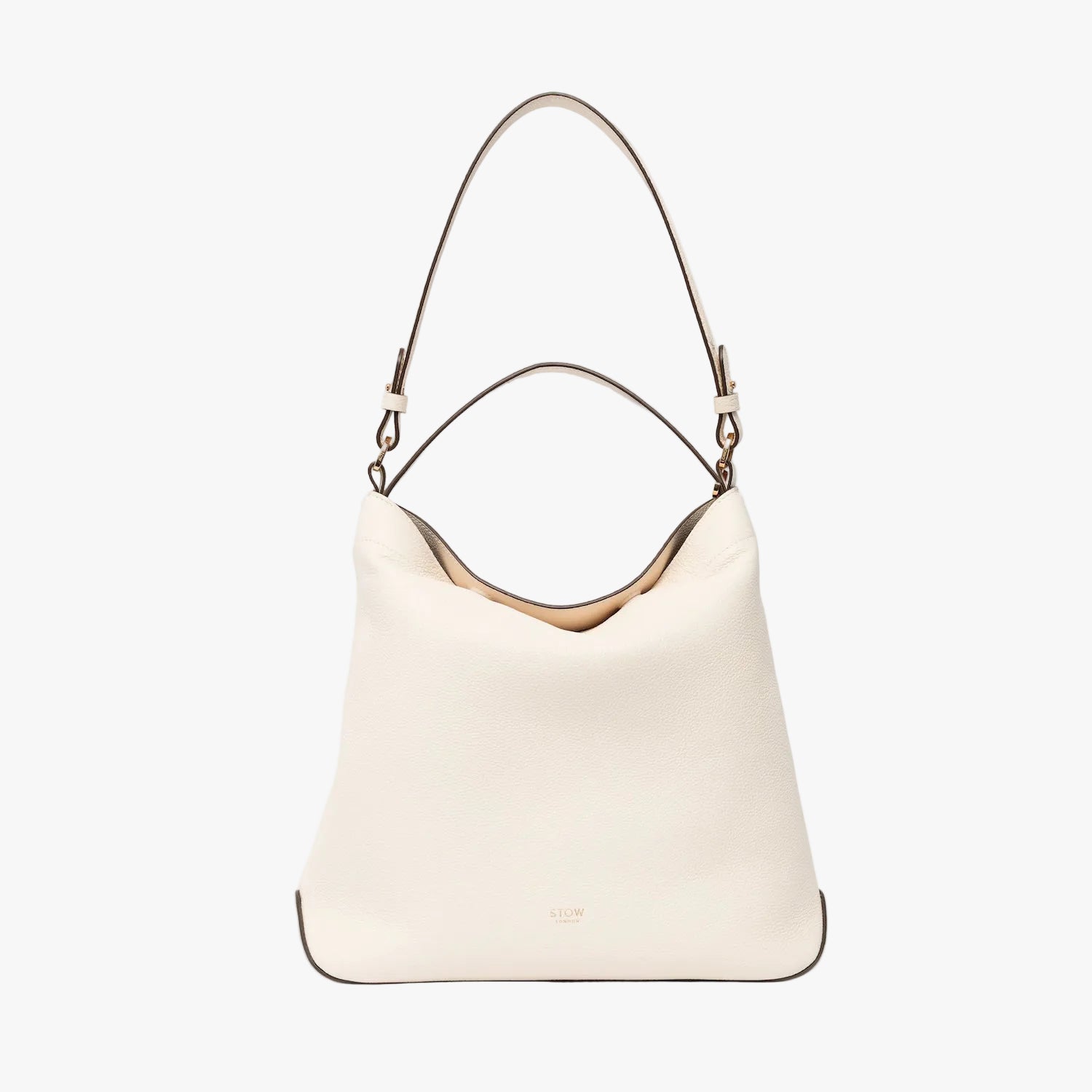 STOW London's Curve in Spring Moon leather on a light grey background featuring the detachable shoulder strap and top handle with gold hardware and details