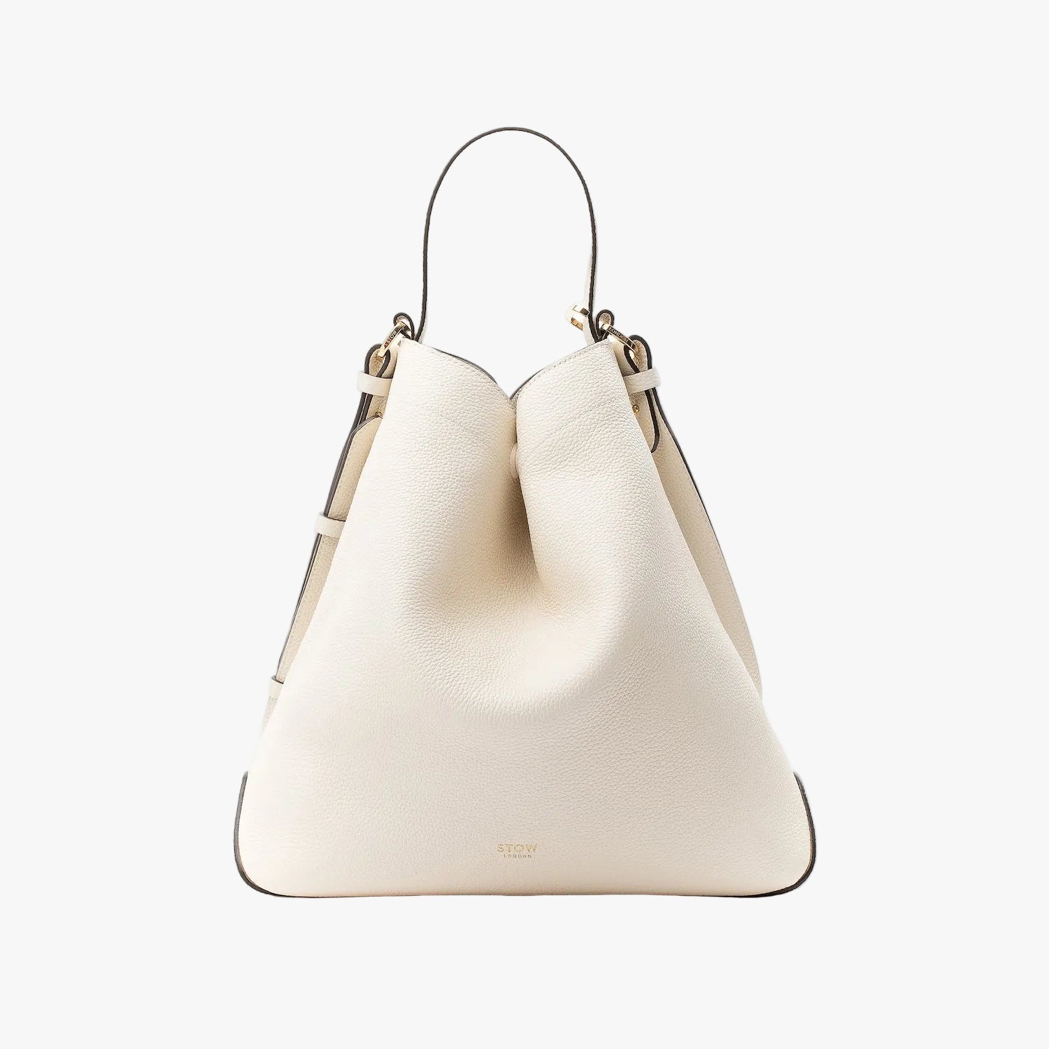 Stow London's Curve bag in Spring Moon pebbled leather in a triangular shape featuring gold-coated stainless steel hardware on a light grey background