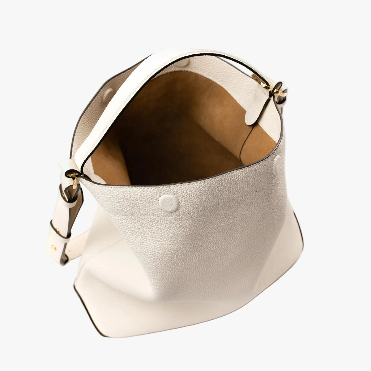 Top angle view ofStow London's Curve bag in Spring Moon pebbled leather showing the cognac suede interior lining ad hidden magnetic closures featuring gold-coated stainless steel hardware on a light grey background
