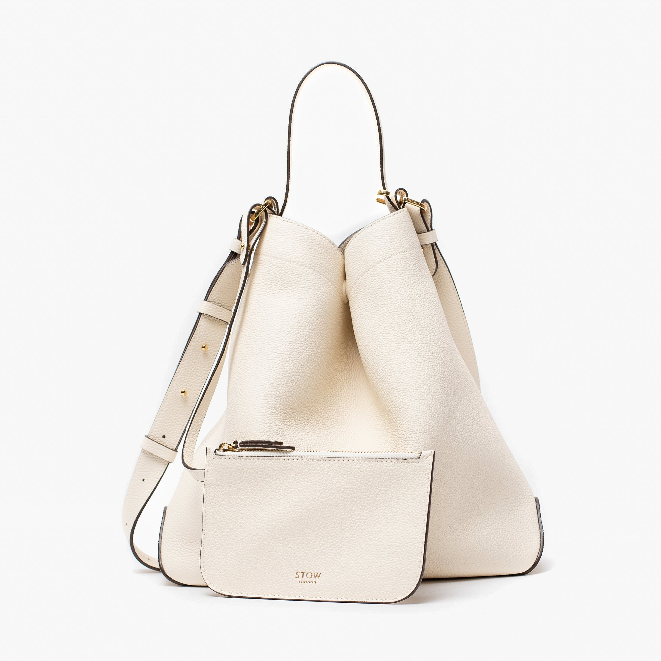 Stow London's Curve bag and matching, detachable interior pouch in Spring Moon pebbled leather featuring gold-coated stainless steel hardware on a light grey background