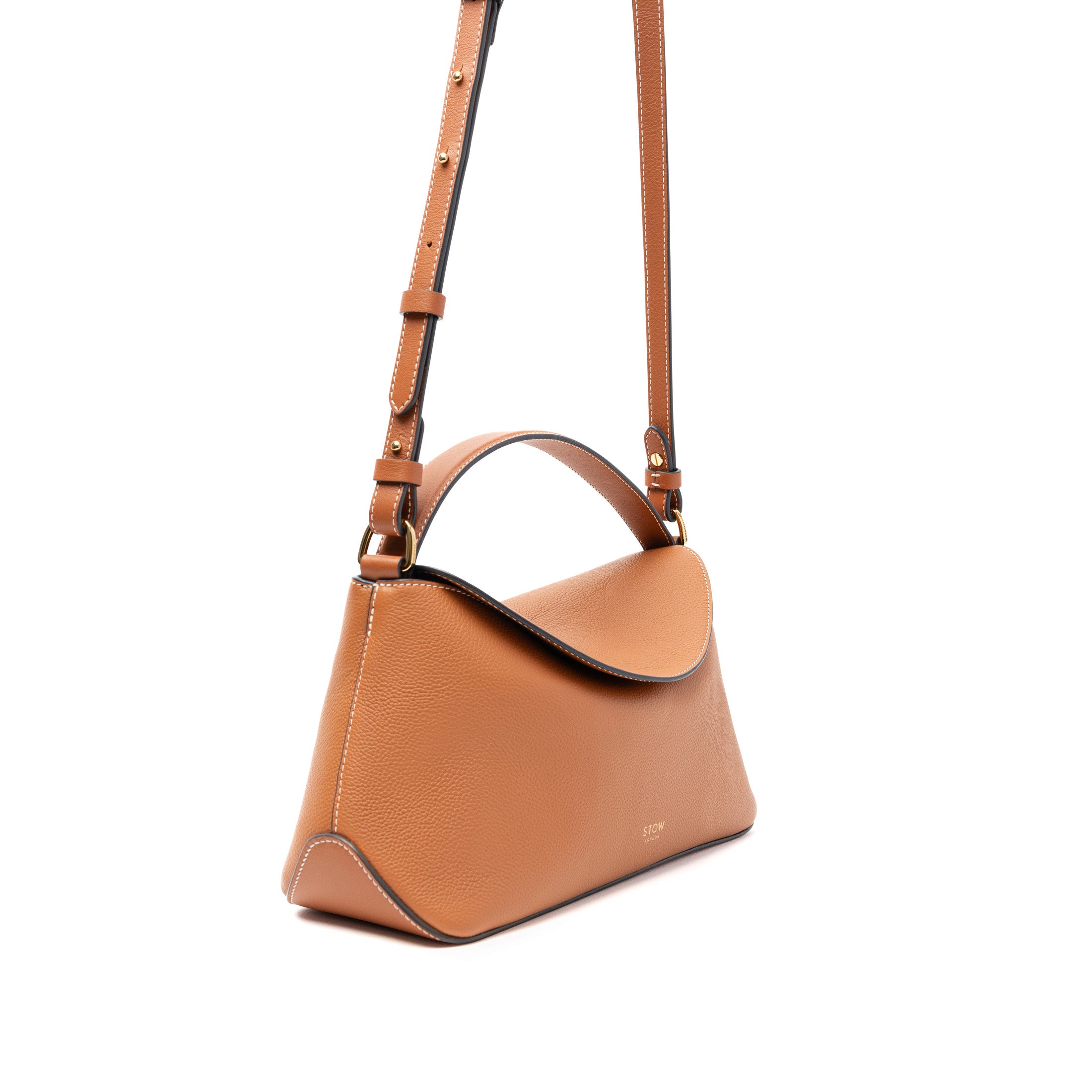 STOW London's East West bag and detachable strap in Earth Tan pebbled and smooth leather featuring gold-coated stainless steel hardware on a white background