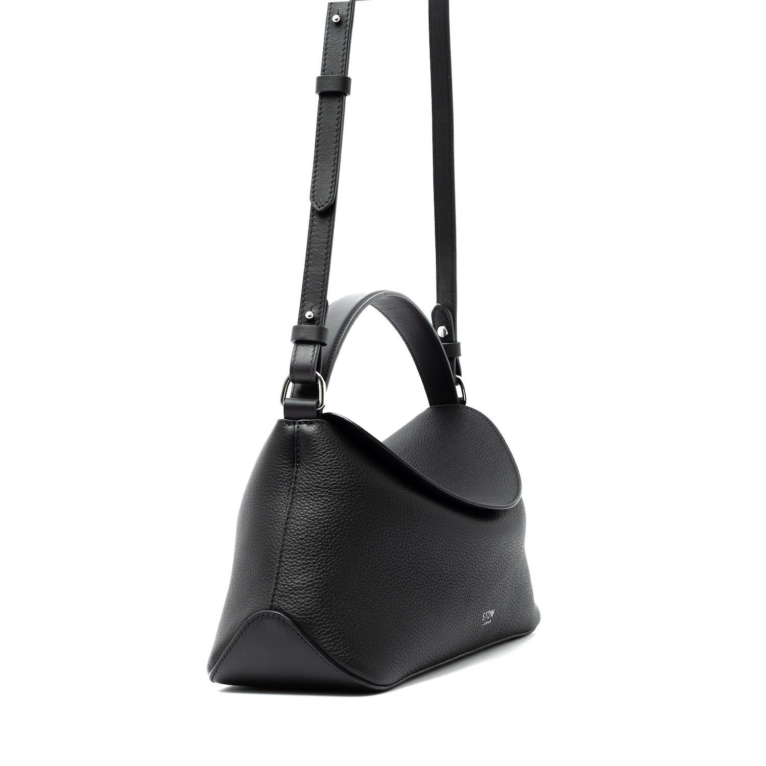 Side view of STOW London's East West bag and detachable, adjustable crossbody strap in Black pebbled and smooth leather featuring silver stainless steel hardware on a white background