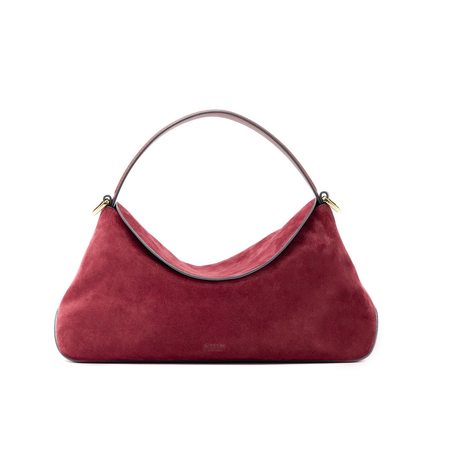 STOW London's East West bag in Burgundy Suede leather in its curved shape featuring gold-coated stainless steel hardware on a white background