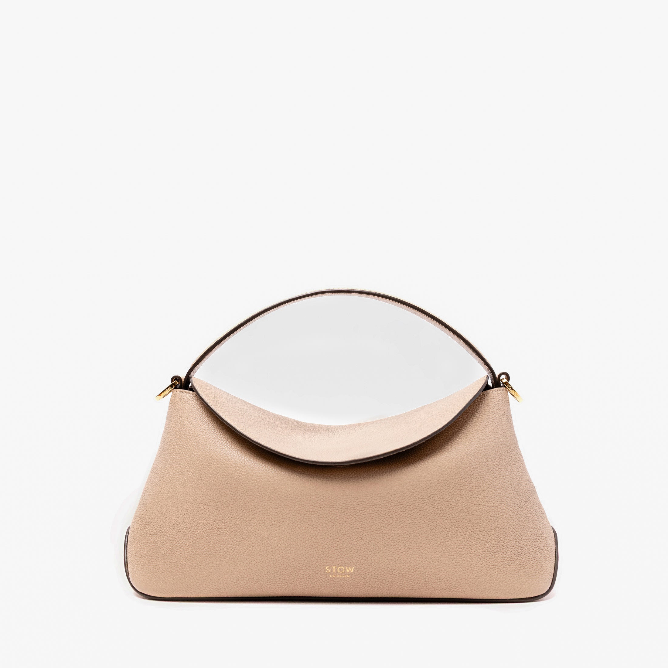 STOW London's East West in Camel pebbled leather featuring gold-coated stainless steel hardware on a light grey background