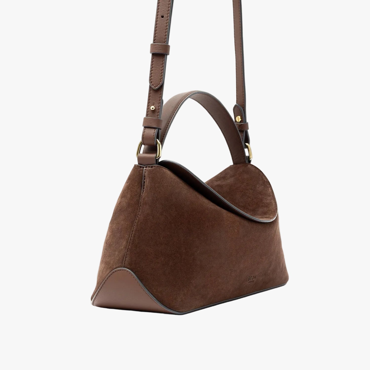 Off-axis view of STOW London's East West in Chocolate suede leather featuring gold-coated stainless steel hardware and its detachable crossbody strap on a light grey background