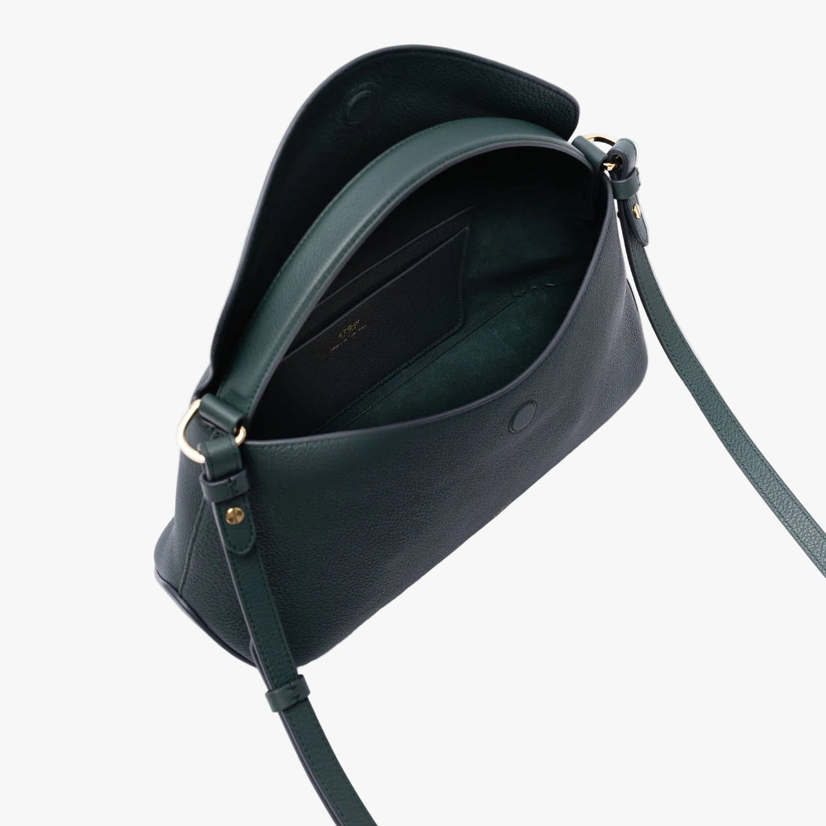 Top view of STOW London's East West in New Forest pebbled leather on a light grey background with the flap open showing the suede interior lining and leather slip pocket