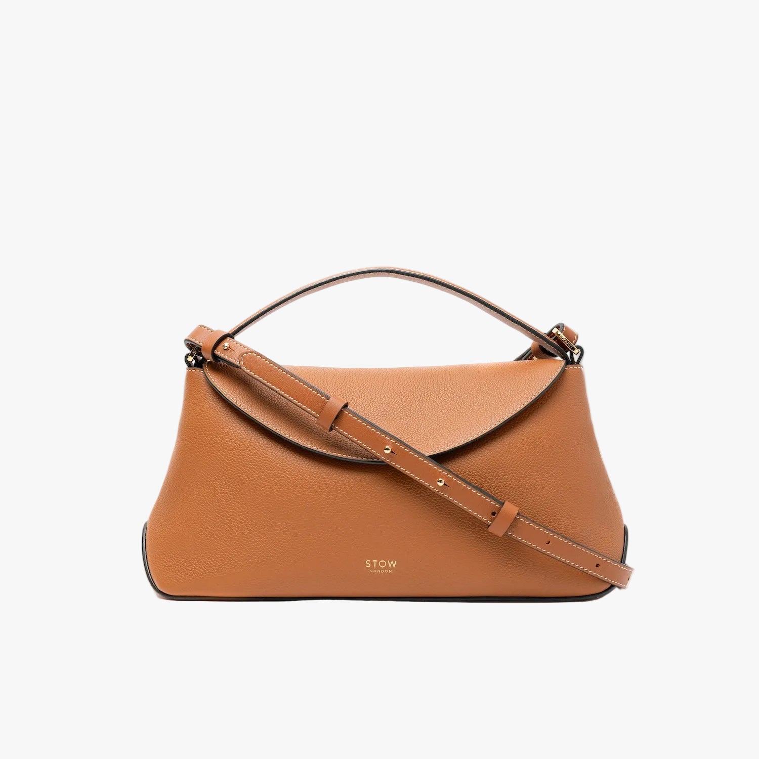 STOW London's East West bag in Earth Tan pebbled leather and crossbody strap featuring gold-coated stainless steel hardware on a light grey background