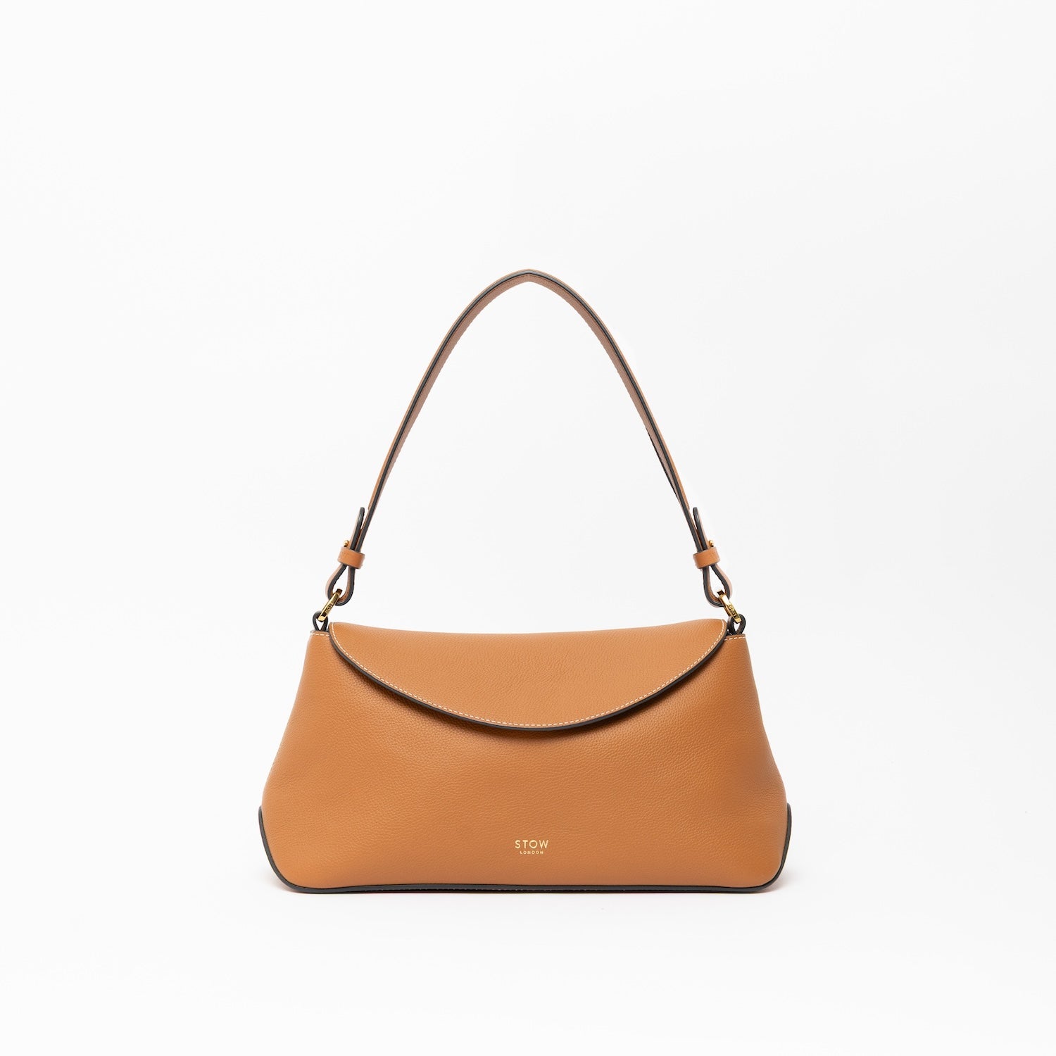 STOW London's East West and detachable shoulder strap in Earth Tan leather on a light grey background featuring gold hardware and details