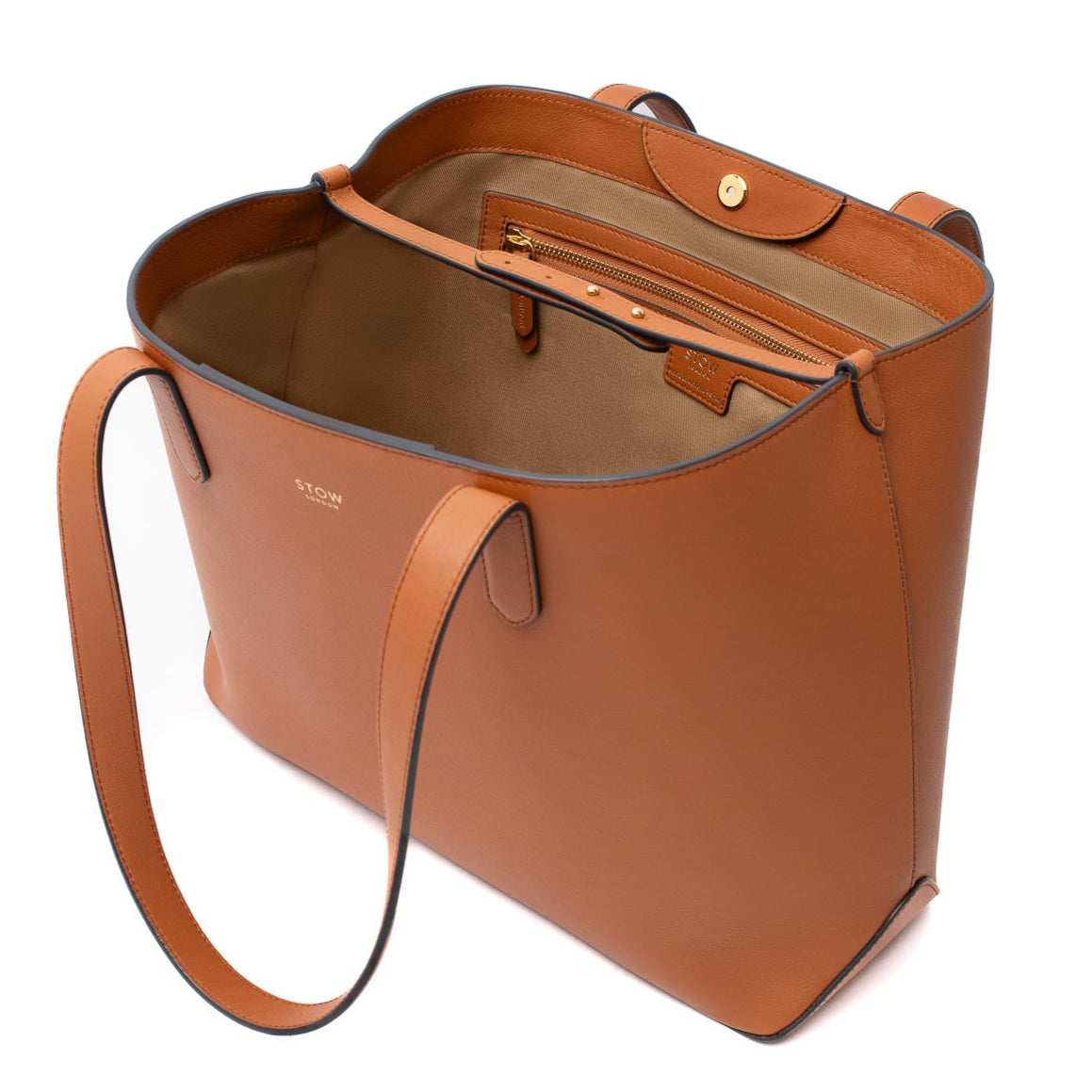 STOW London's Everyday Tote bag in Earth Tan smooth leather with magnets open but interior leather strap attached showing interior zip pocket and beige cotton lining on a white background