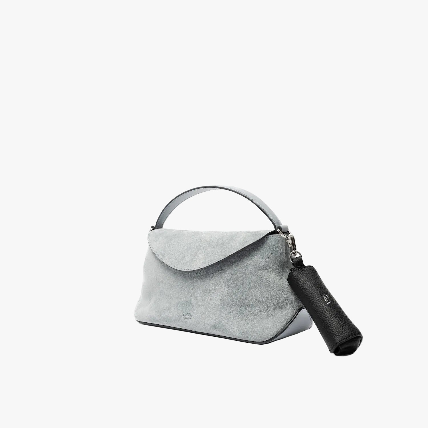 STOW London's Lipstick Case in Black pebbled leather attached by a silver stainless steel clip to the Misty Blue suede Mini East West on a light grey background