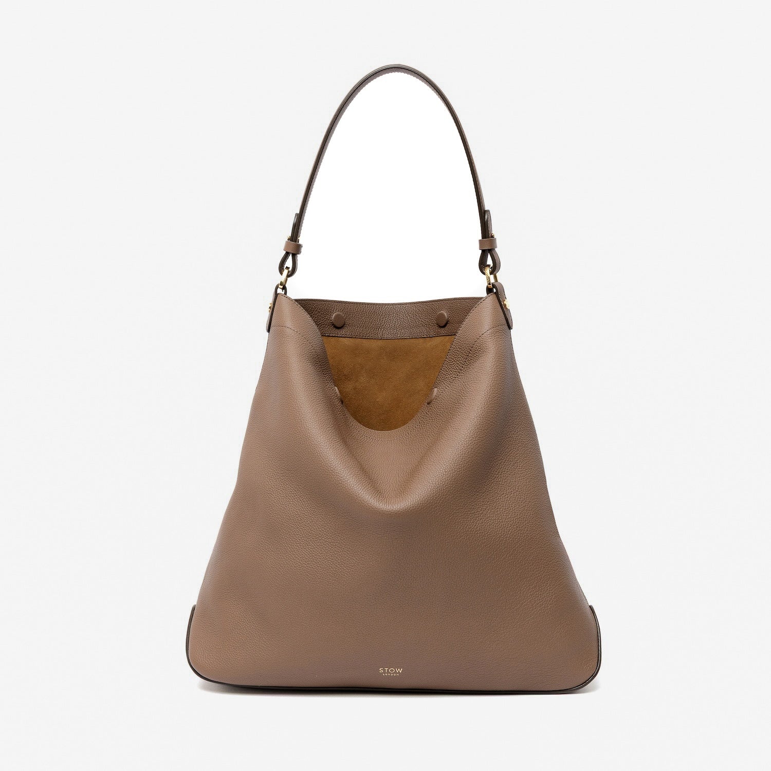 STOW London's Maxi Curve bag in Mocha pebbled leather featuring cognac suede interior lining and gold-coated stainless steel hardware on a light grey background