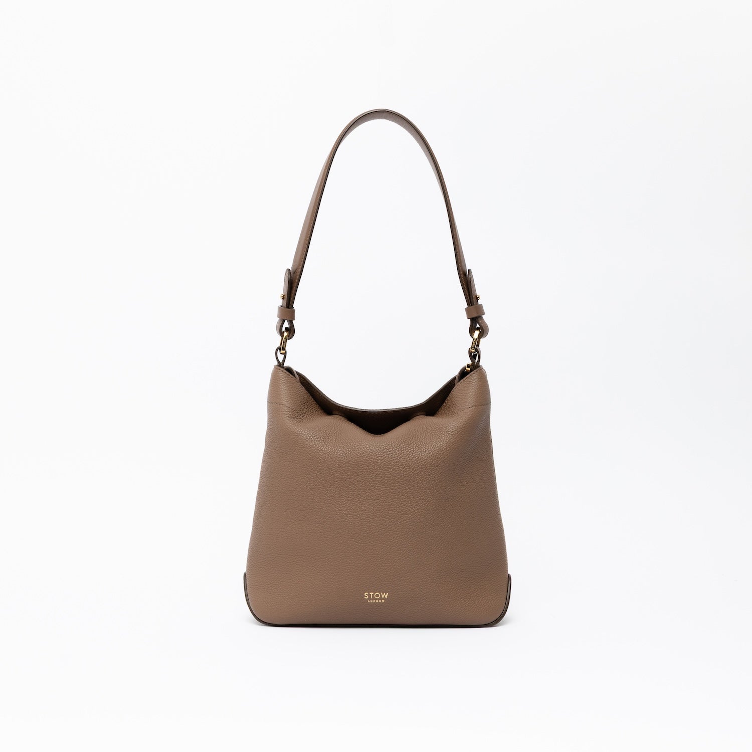 STOW London's Midi Curve and detachable shoulder strap in Mocha leather on a light grey background featuring gold hardware and details