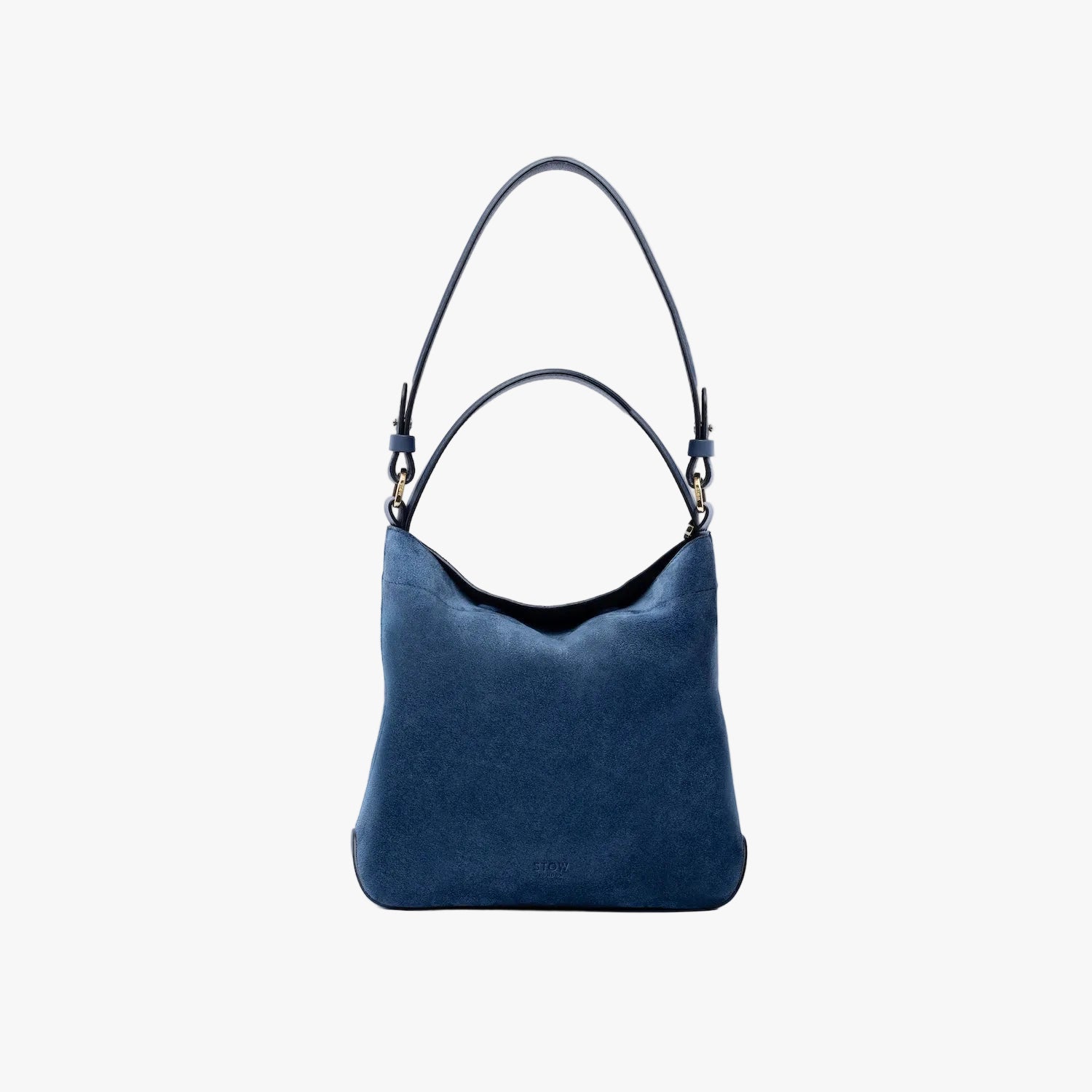 STOW London's Midi Curve in Navy suede leather on a light grey background featuring the detachable shoulder strap and top handle with gold hardware and details