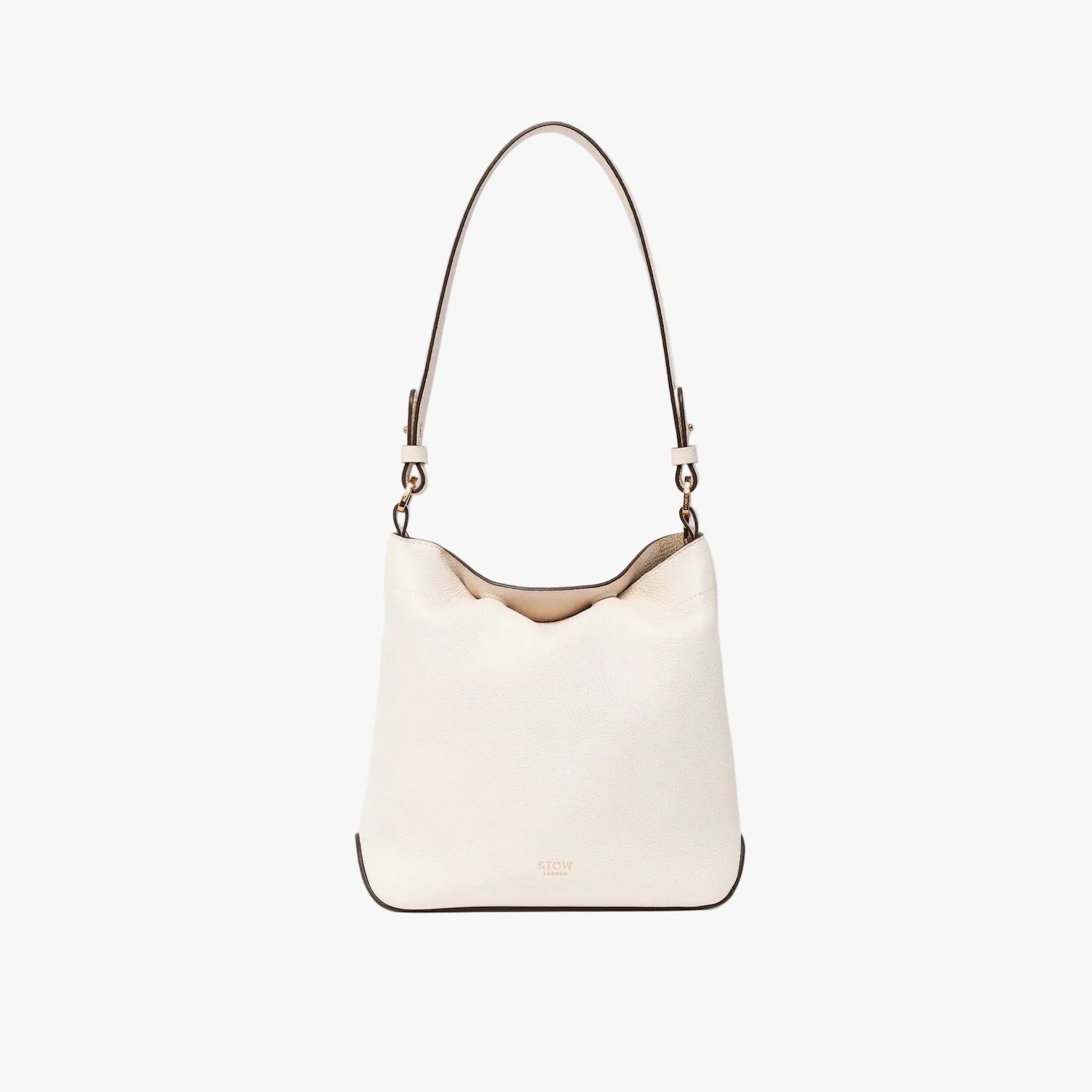 STOW London's Midi Curve in Spring Moon leather with top handle tucked inside the bag on a light grey background featuring the detachable shoulder strap with gold hardware and details