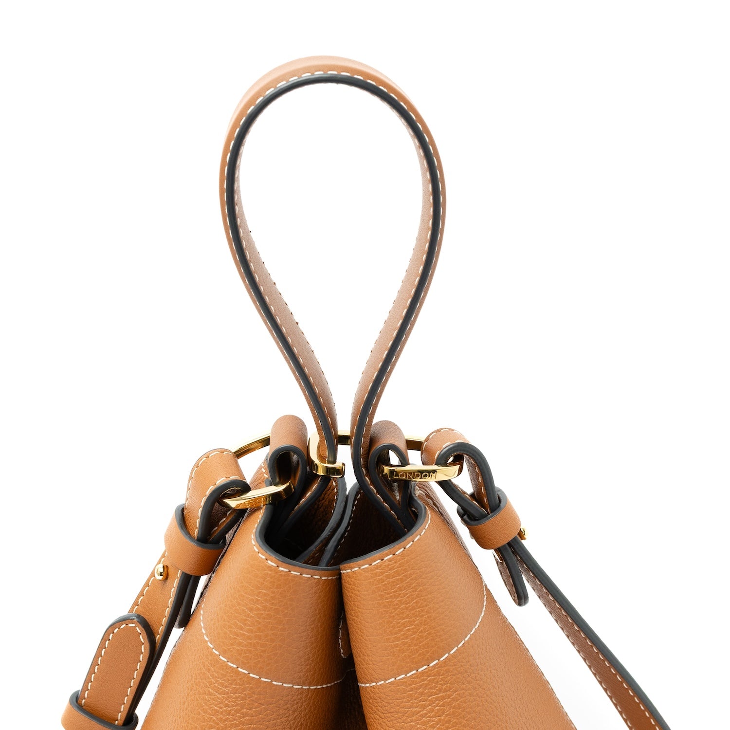 Close up of top handle, clip and detachable strap on STOW London's Midi Curve bag in Earth Tan pebbled and smooth leather featuring gold-coated stainless steel hardware on a white background