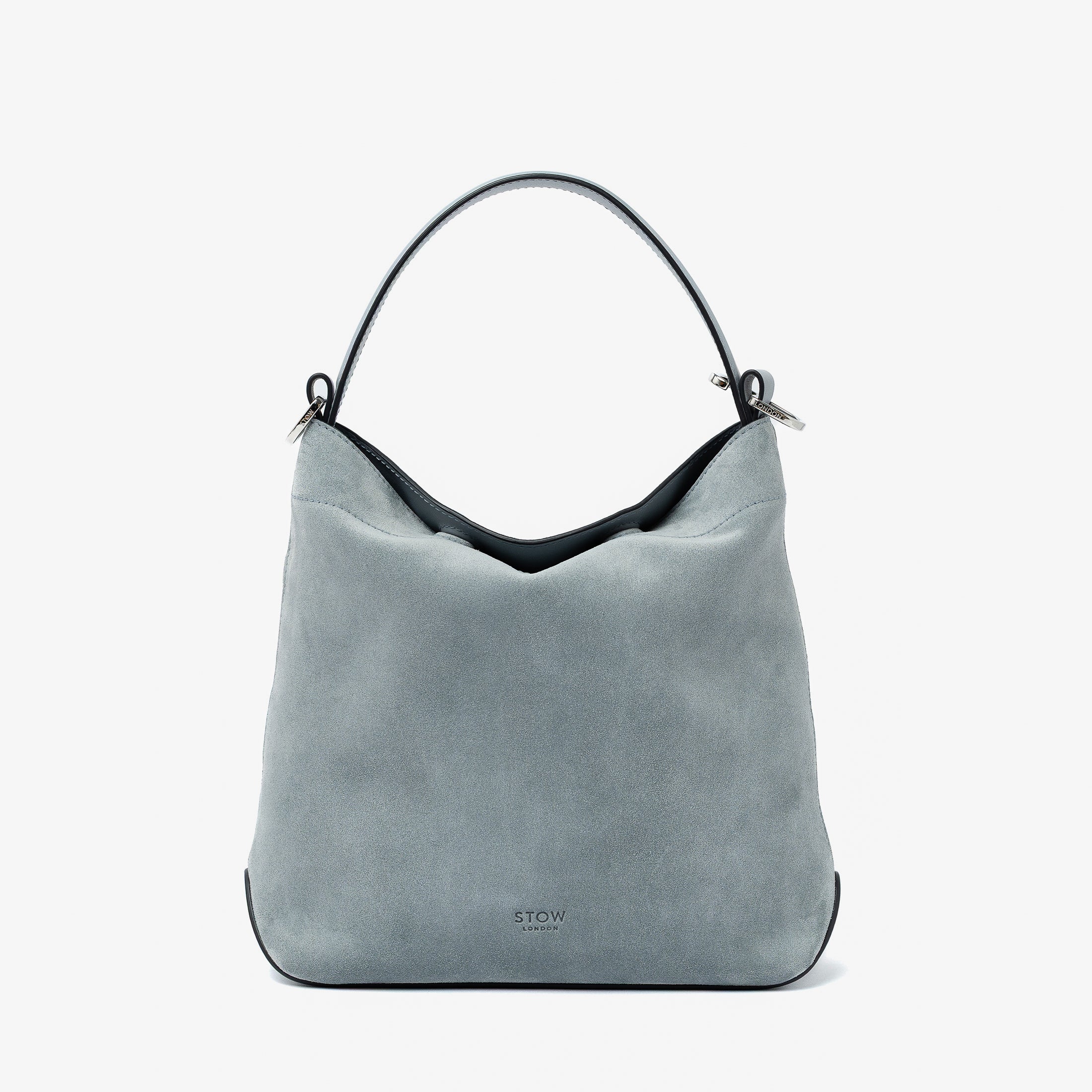STOW London's Midi Curve in Misty Blue suede leather styled as a flap bag featuring silver stainless steel hardware on a light grey background