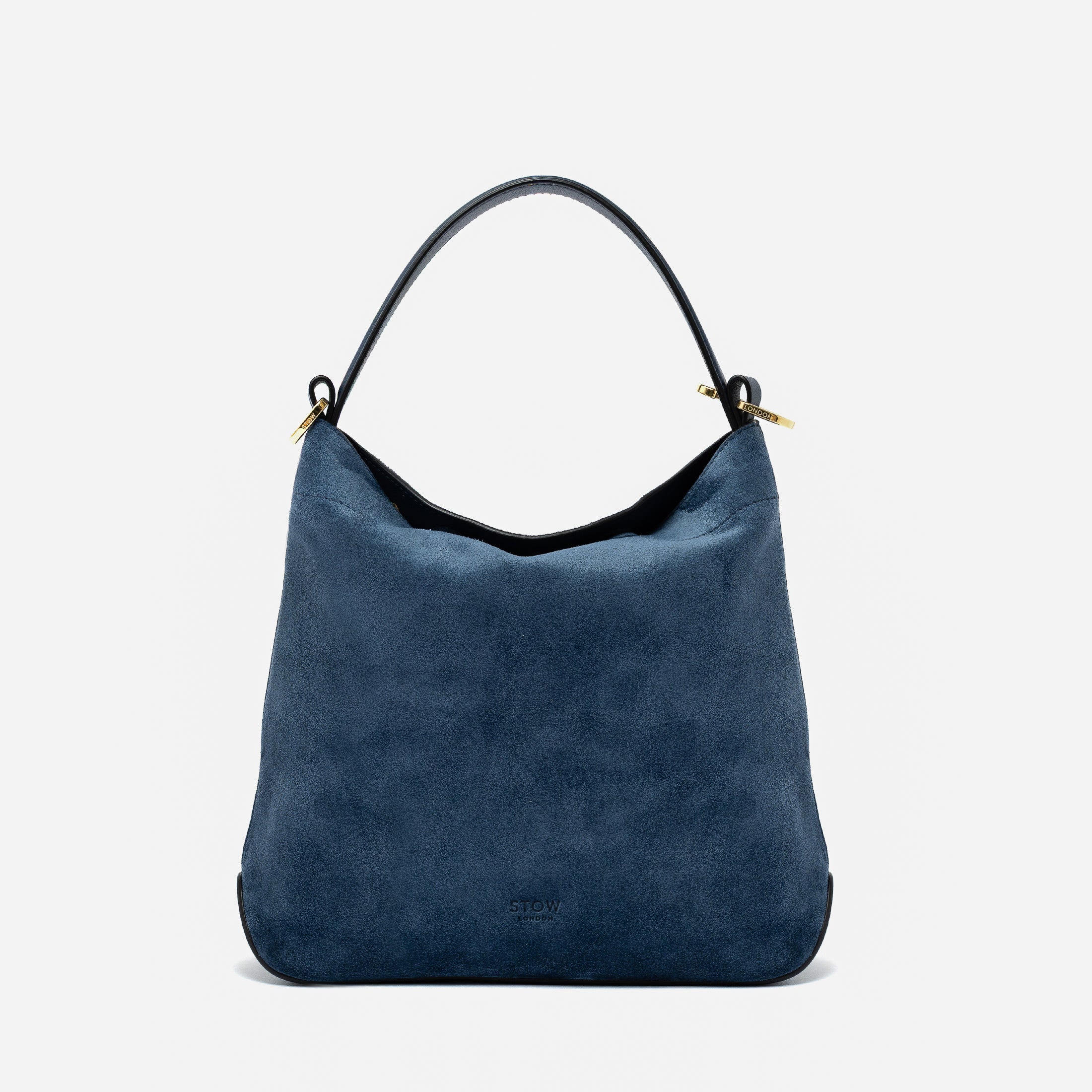STOW London's Midi Curve in Navy suede leather styled as a flap bag featuring gold-coated stainless steel hardware on a light grey background