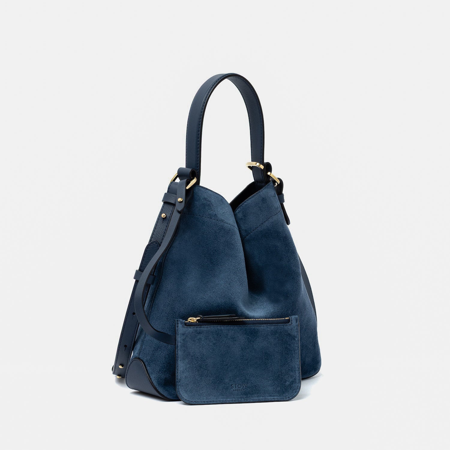 STOW London's Midi Curve in Navy suede leather with the matching, detachable interior pouch featuring gold-coated stainless steel hardware on a light grey background