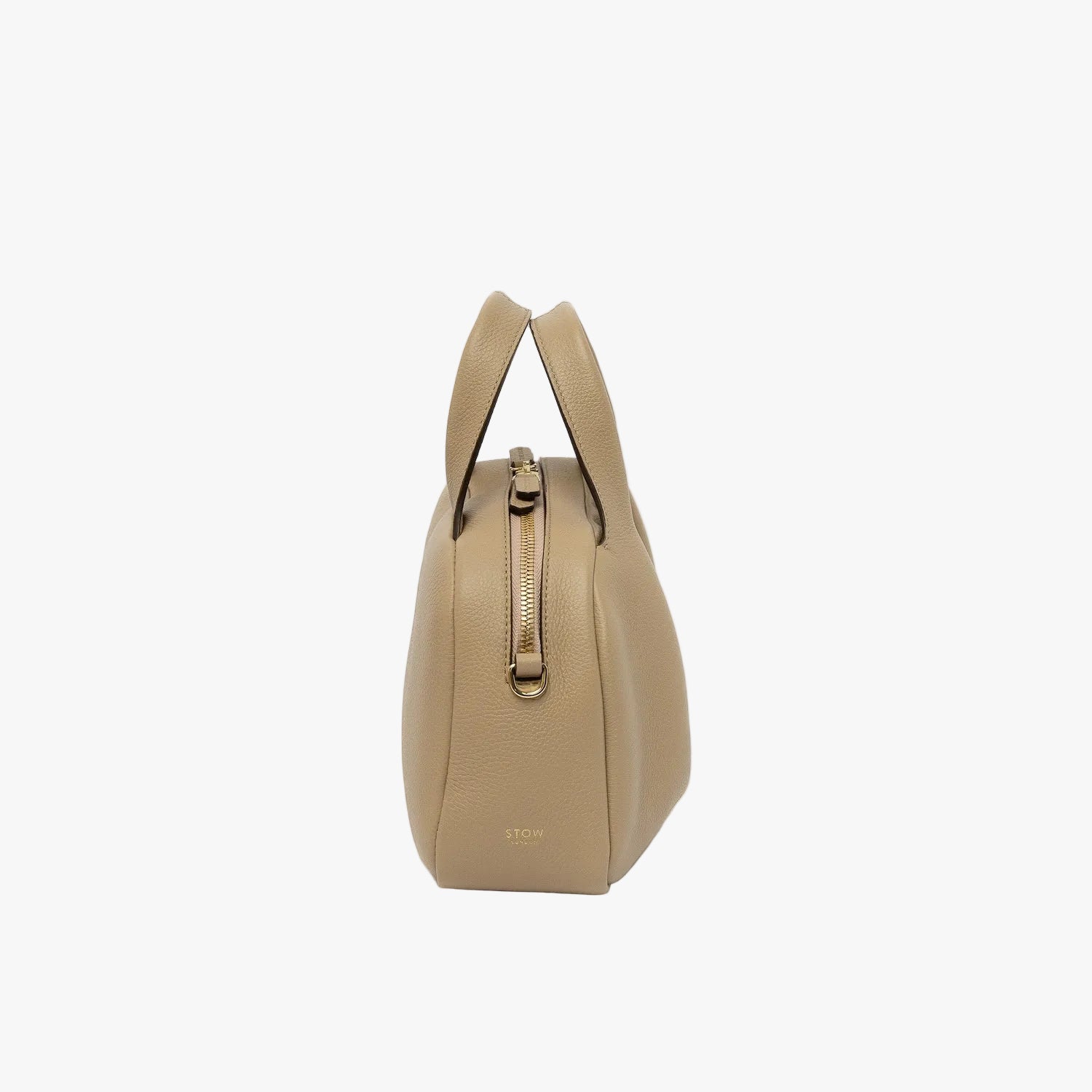 Side view of STOW London's Mini Bowling bag in Camel pebbled leather featuring the zip closure and small gold logo on a light grey background
