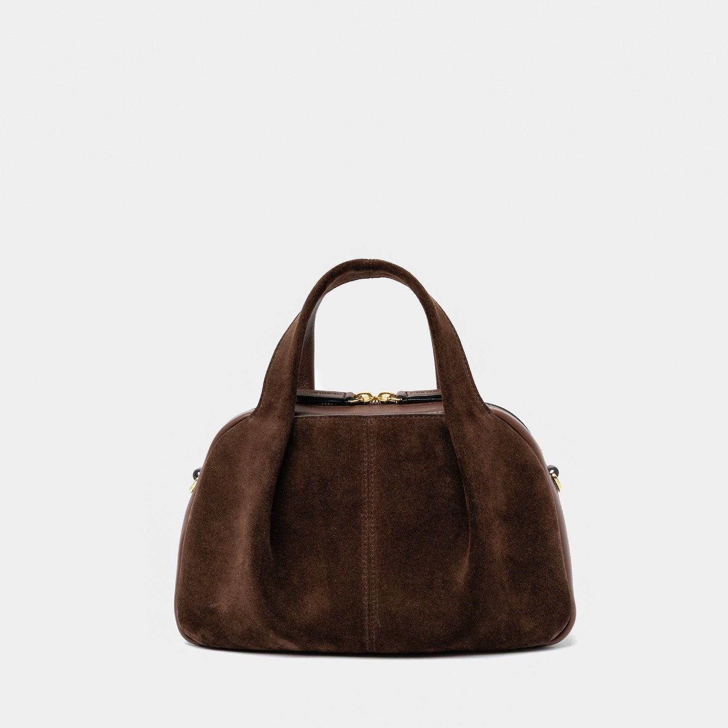STOW London's Mini Bowling bag in Chocolate suede and smooth leather featuring a pleated front panel and gold-coated stainless steel hardware on a light grey background