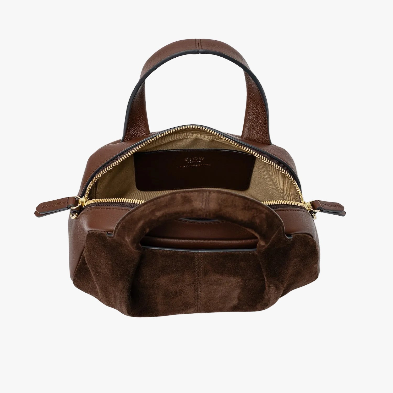 STOW London's Mini Bowling bag in Chocolate suede and smooth leather with zips open showing light beige interior lining and slip pocket featuring gold-coated stainless steel hardware on a light grey background