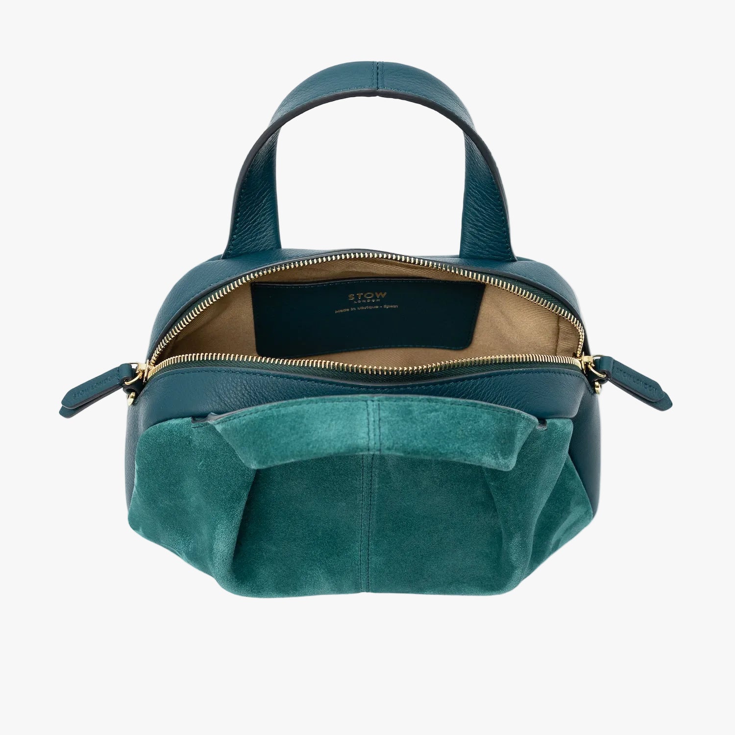 STOW London's Mini Bowling bag in Ocean Teal suede and smooth leather with zipper open showing the light beige cotton interior lining and slip pocket, featuring gold-coated stainless steel hardware on a light grey background