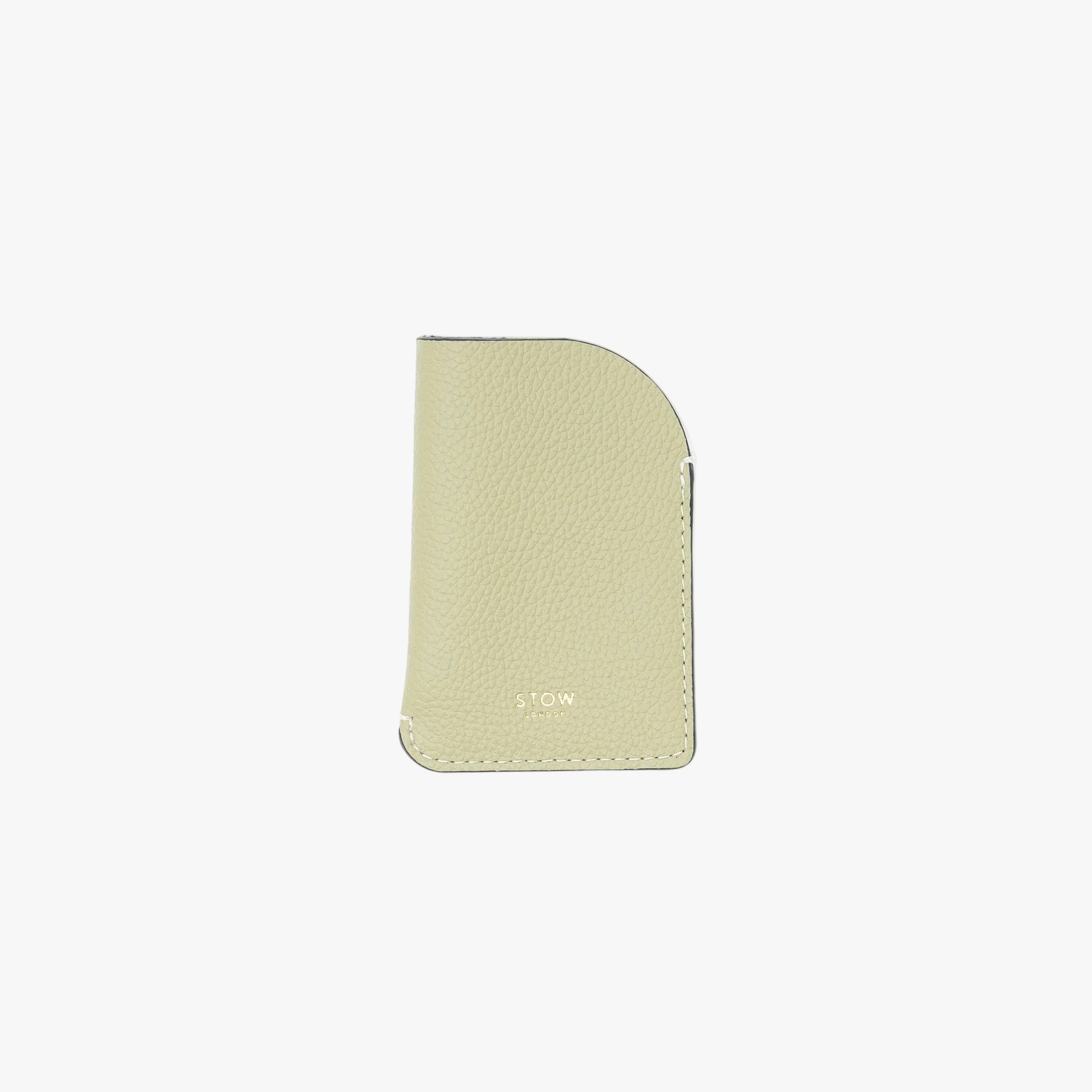 STOW London's Mini Cardholder in Pale Green pebbled leather on a light grey background featuring a small gold embossed logo on the front bottom