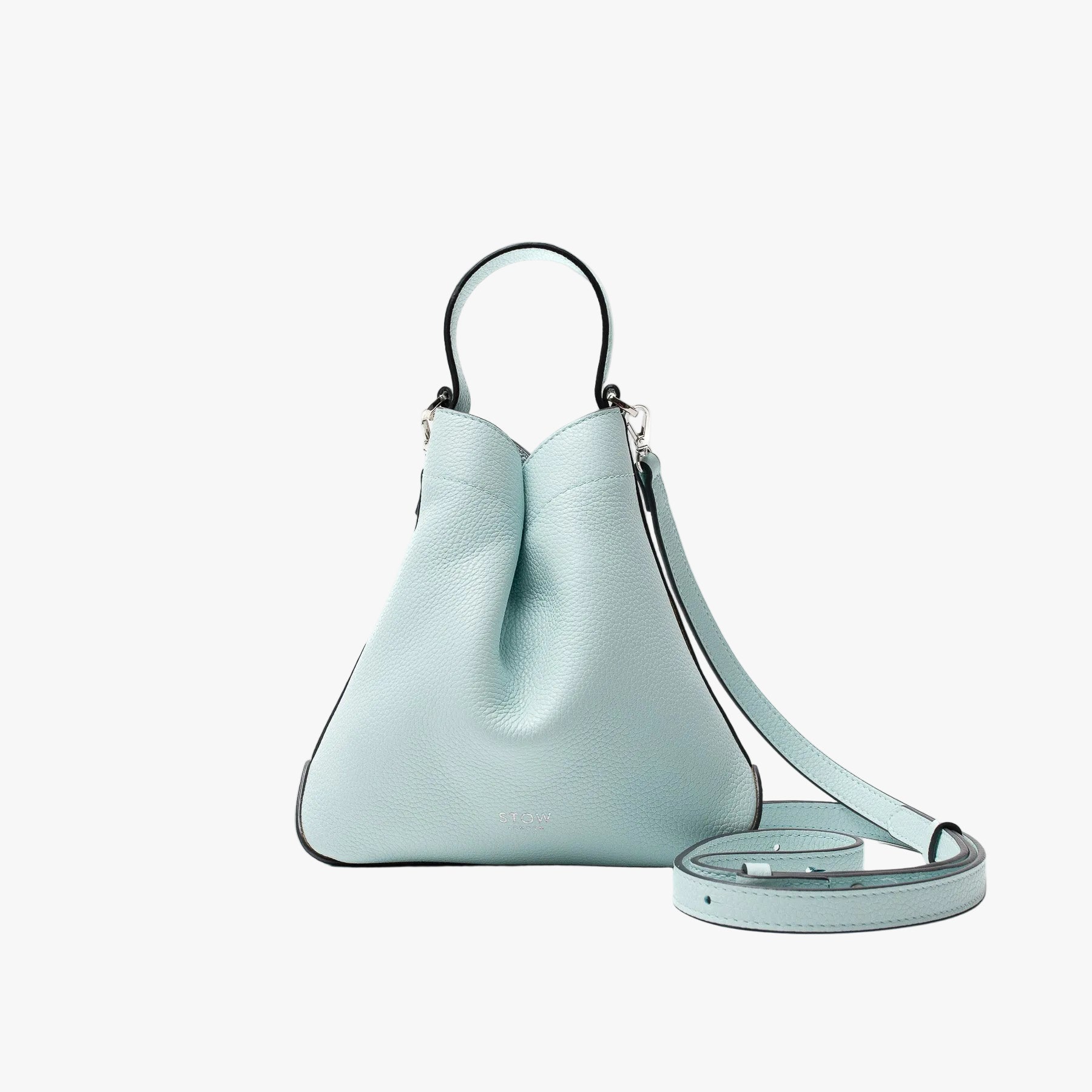 STOW London's Mini Curve Crossbody strap in Celeste pebbled leather on a light grey background