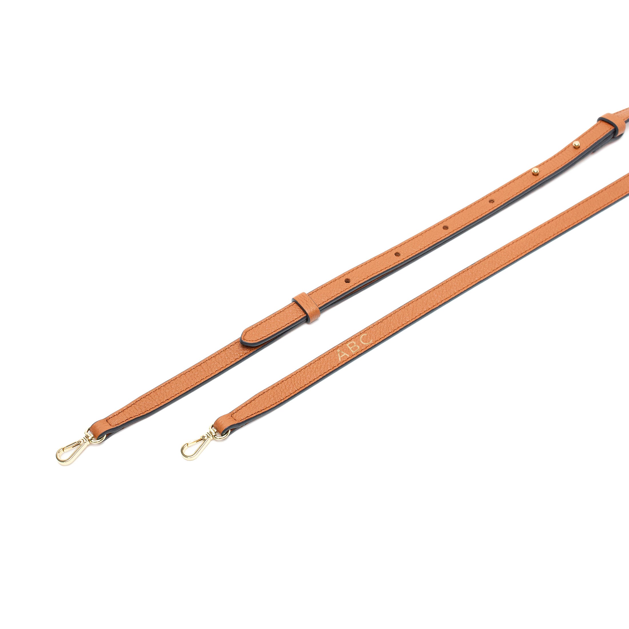 Close up of STOW London's Mini Curve Earth Tan crossbody leather strap with personalisation on a white background