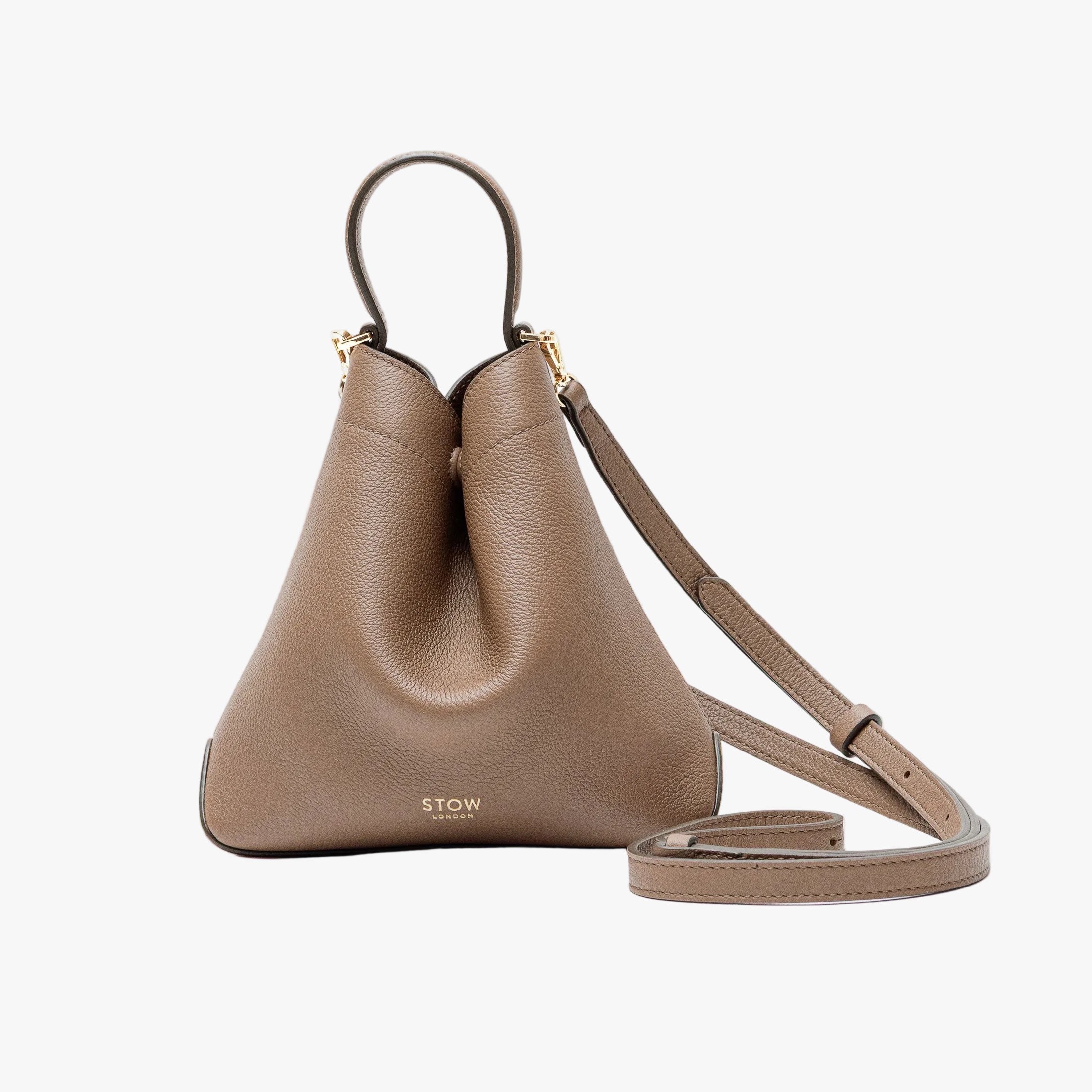 STOW London's Mini Curve in Mocha pebbled leather and detachable leather crossbody strap on a light grey background
