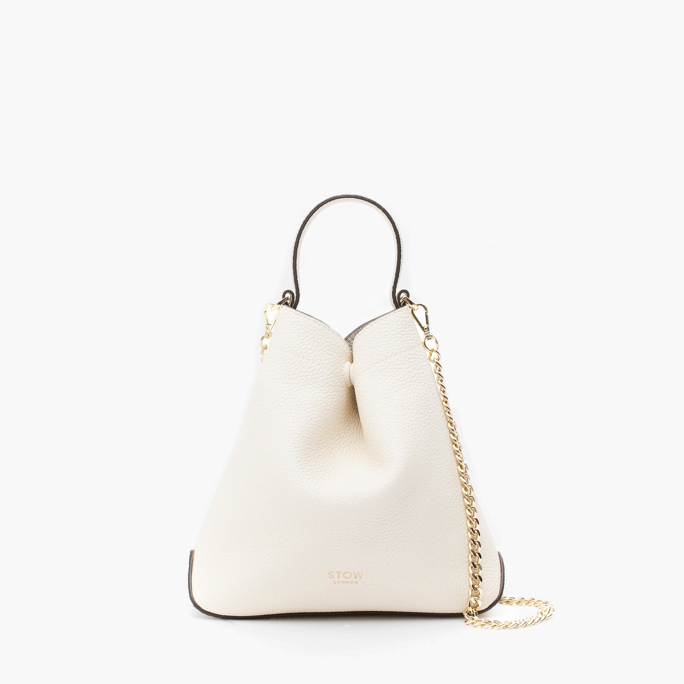 STOW London's Mini Curve in Spring Moon pebbled leather and detachable gold chain crossbody strap styled as a flap bag on a light grey background
