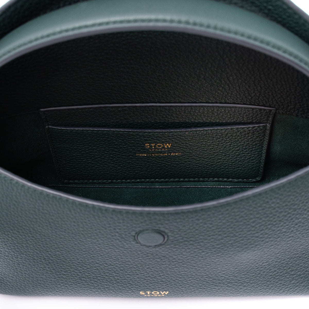 Close up of the interior of STOW London's Mini East West in New Forest pebbled leather on a light grey background featuring the suede lining and leather slip pocket