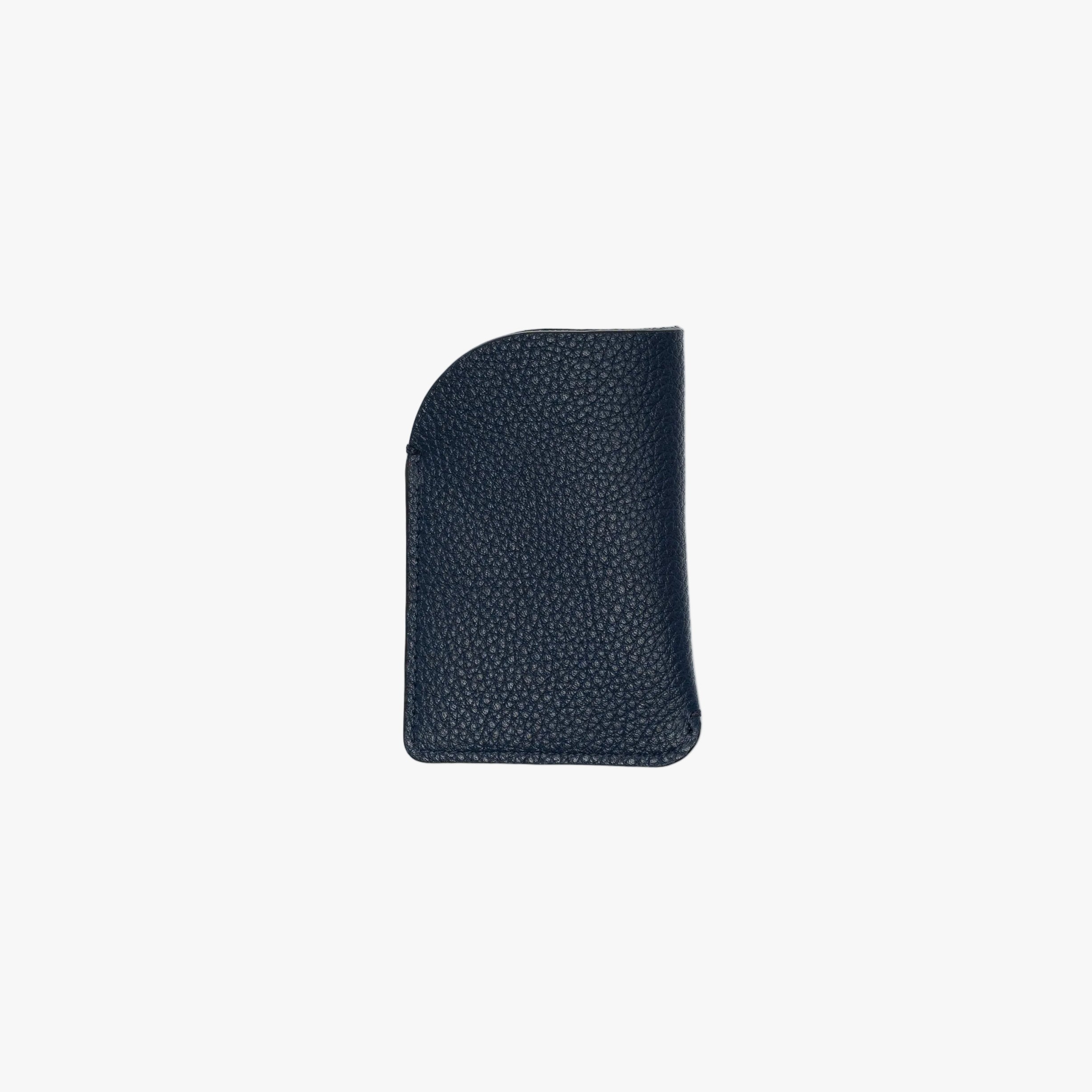 Back panel of STOW London's Mini Cardholder in Navy pebbled leather on a light grey background