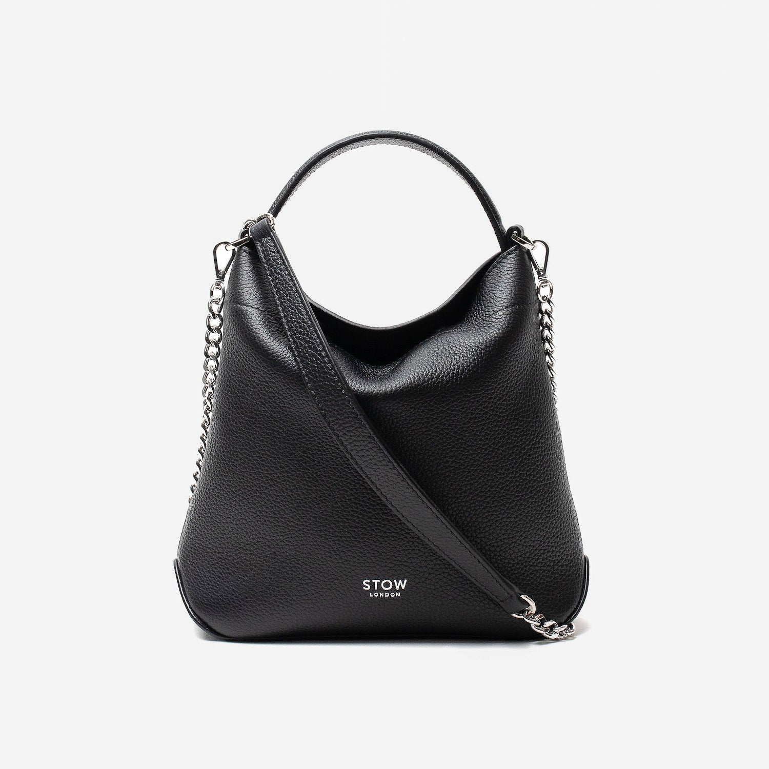 Stow London's Mini Curve in Black pebbled leather and detachable silver chain crossbody strap styled as a flap bag on a light grey background