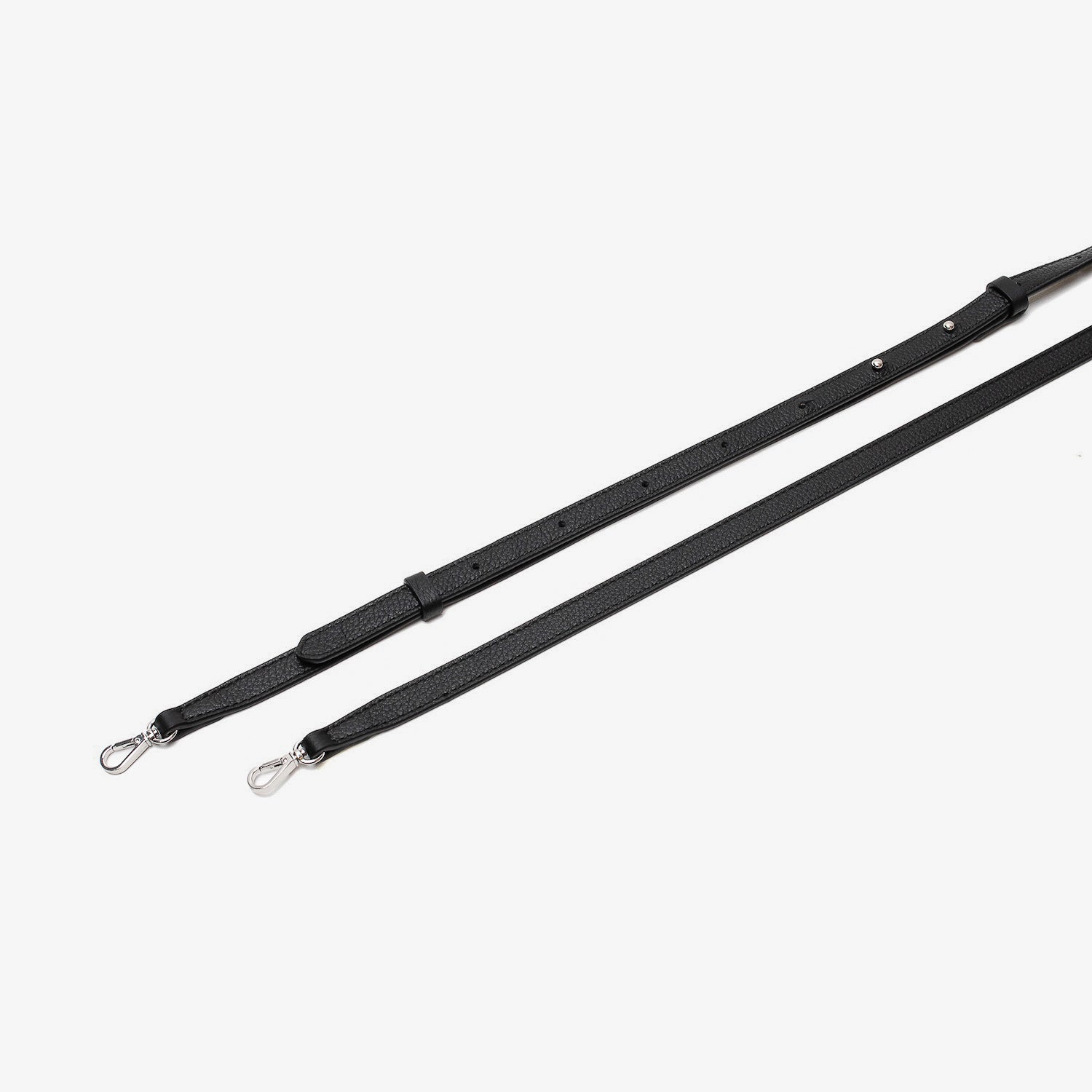 Close up of the detachable leather crossbody strap for STOW London's Mini Curve in Black pebbled leather on a light grey background