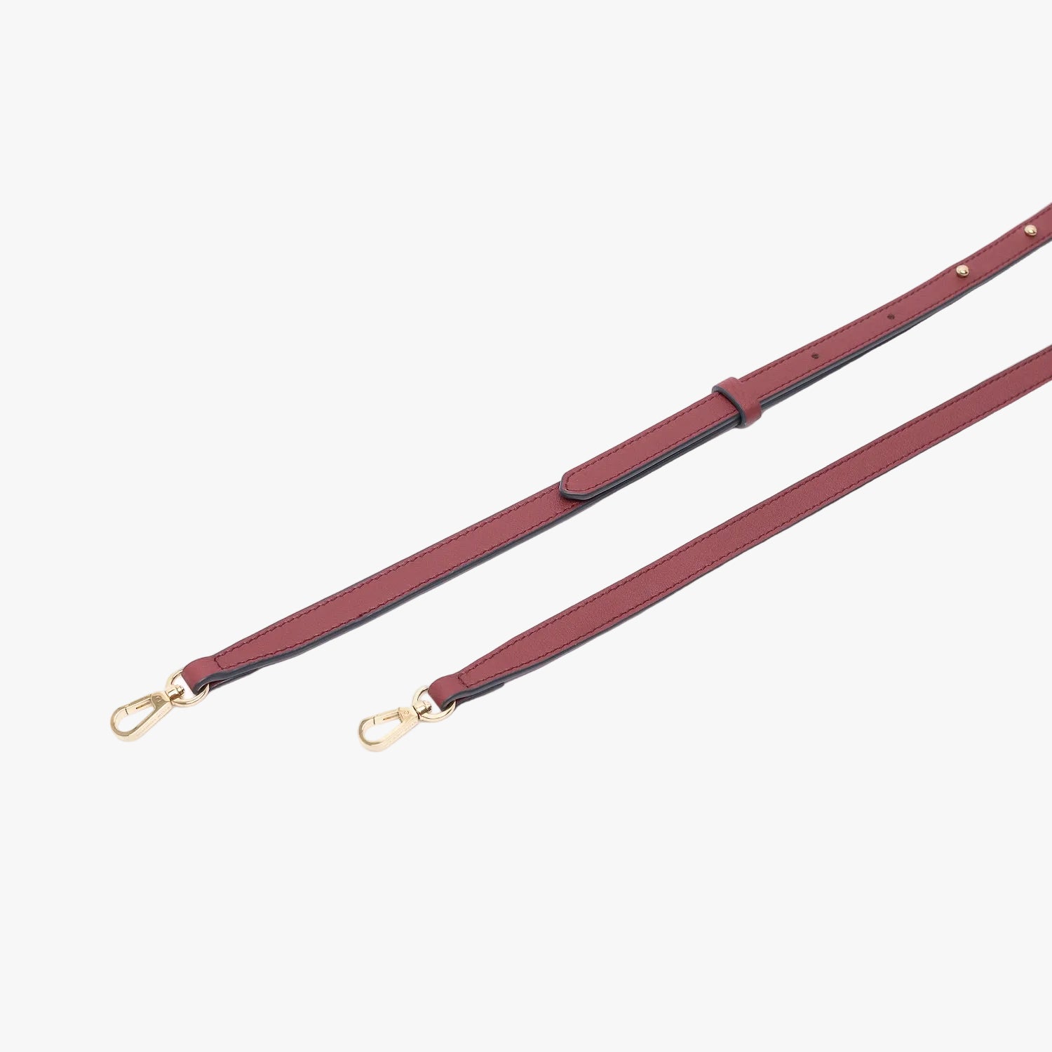 Close up of the detachable leather crossbody strap for STOW London's Mini Curve in Burgundy suede leather on a light grey background